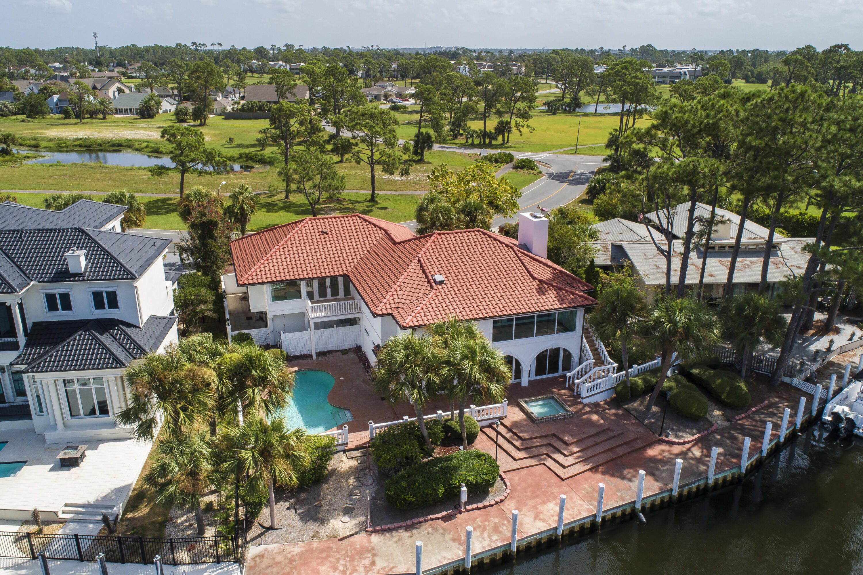 Welcome home to your coastal retreat. Imagine uninterrupted Grand Lagoon views and being able to park your boat in your backyard on a private 110ft dock. Unparalleled water views from nearly every room in the home. A thoughtful and complete renovation while also preserving the charm of custom finishes. Offering duel kitchens and top of the line Viking and Subzero appliance packages. Exterior improvements include a new roof, plumbing fixtures and electrical throughout. This stunning Master bedroom and bathroom gives all the spa like feelings featuring beautiful marble floors and walls, duel bathrooms and closets, a steam shower and separate soaking bathtub with a fireplace and bay view! (see additional remarks) Boasting natural light and vaulted ceilings, the second floor has two guest suites that are private and spacious offering en-suite baths. There is another full kitchen on this floor with custom appliances and formal dining area. Or dine al fresco in the expansive outdoor living and dining areas. This waterfront backyard is perfect for entertaining showcasing multiple lounge areas, a private dock, large private pool and separate spa. The two garage provides private parking with the drive offering spaces for up to 7 vehicles. Bay Point is a resort community providing an experience like no other. Enjoy the privacy and security of a gated and waterfront community, with a beautiful marina, golf course, restaurants, spa and fitness center. There are countless water activities to enjoy year round... pickleball, tennis, golf, paddle boarding, boating, fishing, kayaking... there are amenities for all ages to enjoy! Welcome home. Please contact us for a private tour.