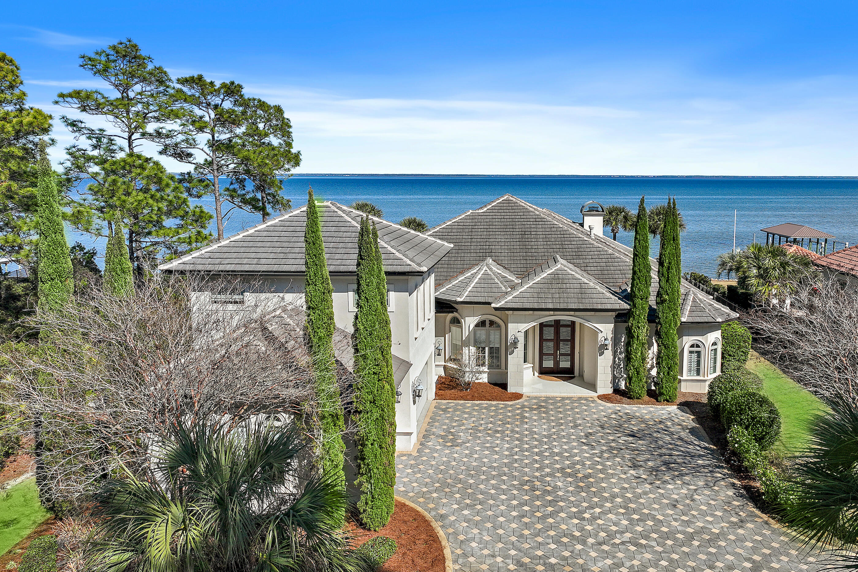 Bayfront Beauty on the Emerald Coast 
Experience the pinnacle of coastal luxury at this exquisite bayfront estate, set along the sparkling shores of Choctawhatchee Bay in Santa Rosa Beach, Florida. Built in 2013 and exceptionally maintained, this Mediterranean-inspired masterpiece offers the rare blend of timeless design, thoughtful upgrades, and an unmatched location on Florida's Emerald Coast.
Primarily a single-level floor plan with a bonus space upstairs, this custom residence spans approximately 3,800 square feet and features 4 bedrooms, 3.5 bathrooms, and an open, light-filled layout that's perfect for both everyday living and elegant entertaining. You'll be welcomed by soaring 12-foot ceilings, stunning wide-plank hardwood floors, abundant natural light, custom built-ins, and a gas fireplaceall creating a warm and refined atmosphere for this luxury home.
The gourmet kitchen is a true showstopper, anchored by an expansive island with seating for 8+ and designed for both function and flair. Features include a gas range, under-counter microwave, ice maker, custom cabinetry, and a breakfast nook with bay views that will take your breath away. Glass doors from the open living space retract to create a seamless indoor-outdoor experienceideal for relaxed Florida waterfront living.
The spacious primary suite is a private retreat with panoramic water views, a cozy sitting area, and a spa-like bath featuring a freestanding soaking tub, oversized walk-in shower, dual vanities, and a custom walk-in closet. This bayfront bedroom oasis is what dreams are made of.
Step outside to your own waterfront sanctuary: a covered lanai with outdoor fireplace and kitchen, a natural gas-heated pool, and a 2017-built dock with a boat lift perfect for sunset gatherings, paddleboarding, or launching a boat right from your backyard. This home is a standout for buyers searching for a waterfront property in Santa Rosa Beach with a private dock and direct bay access.
Additional highlights include a rare 3-car, a paver driveway, whole-home surround sound system, durable stucco construction, and a sleek concrete tile roof. Set on over half an acre, this Emerald Coast estate delivers privacy, sophistication, and direct access to the best of 30A and beyond.
Located just minutes from sugar-white Gulf beaches, five-star dining, boutique shopping at Grand Boulevard (4.7 miles), and award-winning golf at Sandestin Golf & Beach Resort and Santa Rosa Golf & Beach Club, this home sits at the heart of the Florida Panhandle's most sought-after lifestyle destinations. Outdoor lovers will also appreciate nearby Topsail Hill Preserve State Park (6.2 miles), offering hiking, beach access, and natural beauty year-round. The community also features Driftwood Estates Park less than a mile from the home, with tennis, pickleball, basketball, and a playground for everyday recreation.
Santa Rosa Beach real estate continues to attract discerning buyers for its exceptional schools, nationally recognized parks, and world-class coastal amenities. Whether you're seeking a full-time residence or a second home on the water, this property offers an extraordinary opportunity to live in one of the most desirable bayfront locations in Northwest Florida.
Don't miss your opportunity to own a piece of waterfront elegance. Everyday comfort, spectacular views, and the best of beach living await at 1201 Driftwood Point Road.