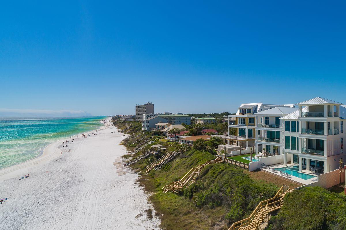 Newly completed and primely positioned this sleek coastal contemporary Gulf front compound is perfectly situated in the heart of Seagrove Beach characterized by panoramic beach views from each of it's impressive three levels as well as the covered fourth story rooftop deck. This is the ultimate beach home; configured to provide unparalleled amenities and optimized for entertaining with notable features including a resort style gulf front pool area & spa situated almost 25' above the beach yielding unmatched water views as well as optimal privacy. This incredible home is situated on a massive oversized 52x390' homesite allowing for a private parking court with two car garage (with additional storage) as well as a golf cart garage in the carriage house. The detached carriage house is complete with a full kitchen, bedroom suite, laundry area and bathroom as well as a top floor living room that enjoys beautiful gulf views. In the main house, the first level bar and game room overflow onto the covered pool deck characterized by floor to ceiling glass windows and featuring beautiful coral stone flooring. The pool deck features ipe decking leading to the pivate beach walkover, surround sound and a concrete privacy wall. The resort pool offers a perimeter overflow spa and beautiful water feature adjacent to the covered outdoor kitchen & lanai complete with a custom summer kitchen and outdoor television; perfect for entertaining. is open to the 40,000 gallon watermark-built private resort style pool area complete with a swim up bar as well as an adjoining spa and covered outdoor summer kitchen & living area with gas fireplace. 

This property is an investment magnet with $500,000-$600,000 in gross projected annual rental income. Other notable features include multiple indoor and outdoor living areas, private commercial grade elevator, expansive third floor master suite withfloor to ceiling glass to enjoy endless gulf views as well as an adjoining spa like bathroom with floor to ceiling marble, large soaking tub and dual vanities. There is an indoor and outdoor surround sound system as well as security cameras for optimal privacy. The first floor layout boasts a full living/game room overlooking the Gulf of Mexico, as well as a large bedroom suite and pool bathroom. The second floor is the focal point of indoor living space with a spacious living room featuring pecky cypress ceilings, floor to ceiling windows to soak in the beautiful gulf views, gas fireplace, built-in entertainment center and open to the massive dining area which has forever western and southern exposures to soak in the sunset over the beach. The ample sized kitchen features floor-to-ceiling custom cabinetry, paneled Sub-Zero appliances and Wolf professional series gas range, walk-in pantry and large center island with gorgeous quartz countertops. The second floor also features a bunk room as well as two full bedrooms with ensuite bathrooms & half bath as well as access to the second story outdoor living area overlooking the Gulf of Mexico. The third floor is the master level and features an impressive King suite with ensuite bath, spacious living room & beverage station as well as three additional bedroom suites including a bunk room. There are two laundry stations in the main house as well as access from the third floor to the fourth story deck ideally outfitted with a covered living space and offering ample seating to enjoy the panoramic views of the Gulf of Mexico. Seagrove Beach is located in the heart of 30A near world class shopping, dining and entertainment as well as excellent proximity to Seaside FL and the new urban lifestyle that 30A has to offer.