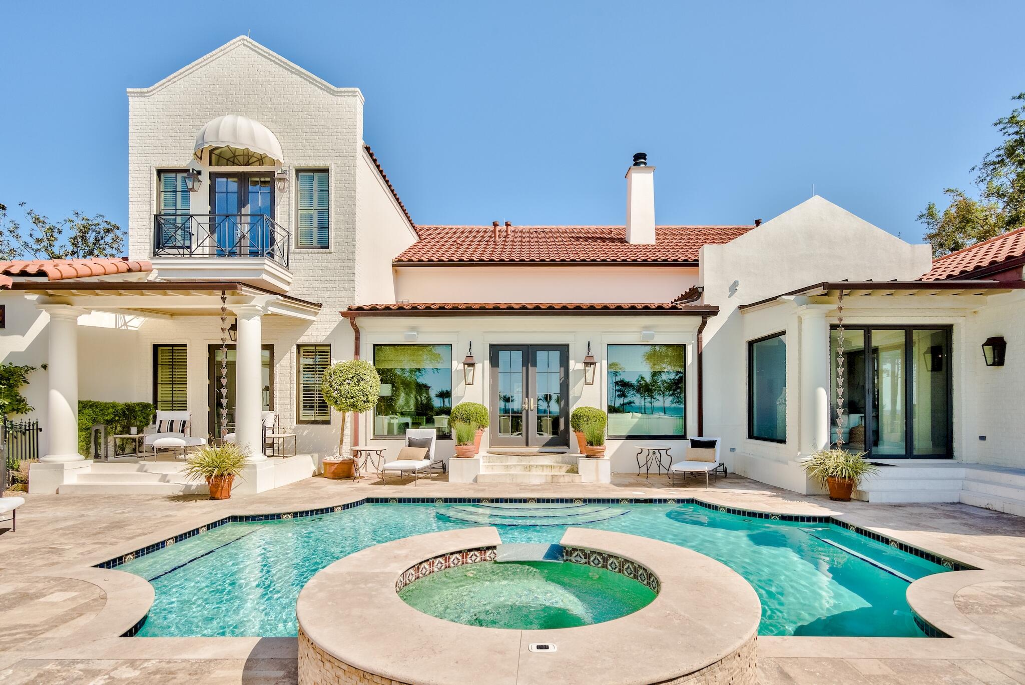 Timeless details and breathtaking views abound in this rare and private estate. Designed as an exclusive celebrity compound, this property is the only one of its kind in the prestigious gated community of Burnt Pine and provides privacy and safety for the most exclusive buyer or cautious family. As you enter the property through its own private gates and lavish courtyard, you find a lush garden framing the main home while the garage and guest house provide a beautiful enclosure from the quaint neighborhood street. Sweeping views of Choctawhatchee Bay water and the Burnt Pine Golf Course greet you the moment you step inside the stunning main residence. An entertainer's paradise at every turn, the classic white coral stone floors throughout the main living area and soft neutral tones layer plus an enclosed separate grilling area and pizza cookery. The beautiful pool lanai and the panoramic backdrop of the golf course stretching into the bay beckons everyone to enjoy the gorgeous outdoors. Covered porches stretch languidly along the house.
Endless long windows from every room draw the incredible view inside. This premier home, once featured in Veranda Magazine, lends to the imagination creativity with the highest regard for design.

Burnt Pine is a gated community in Sandestin Golf and Beach Resort. Sandestin offers a marina, beach access, 24 hour free tram service, tennis courts, swimming pools, concert areas, world famous restaurants and shopping, renowned golf courses, and miles of bike/walking trails.