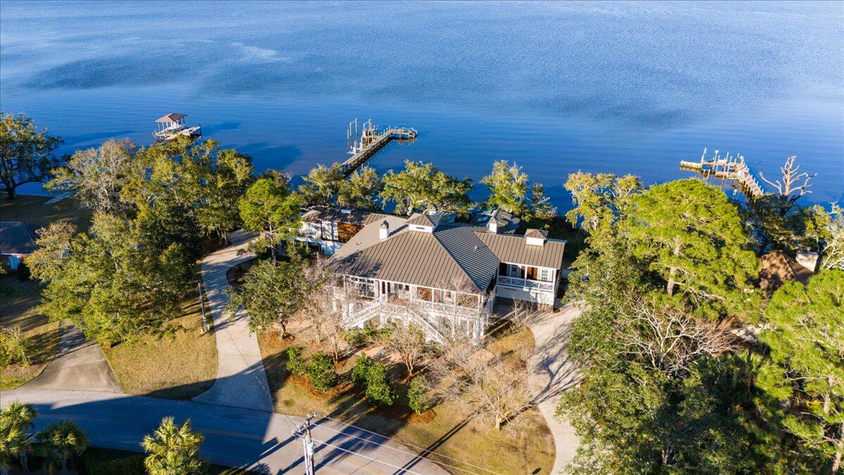 Bay front dream home offered turn-key ready and Fully Furnished! Perfectly located with just a short drive to 30-A, close to the 331 bridge for easy I-10 access, and amazing neighborhood restaurants you can quickly get to also by boat such as North Beach Social, The Bay, Farm and Fire, and the San Destin Bar & Marina! Crab Island and the Gulf of Mexico are a quick boat ride away. Nestled at 1331 East Nursery Road, this expansive estate boasts 5 bedrooms and 5.5 bathrooms, could sleep 15, offering serene vistas of the Choctawhatchee Bay with fire pit and Adirondack chairs, perfect for sunsets. It features a private boardwalk that extends across the property and includes boat lifts suitable for various watercrafts, complemented by jet ski lifts for aquatic activities. The property also includes a YOLO/Kayak storage room equipped with racks. 
The estate has undergone extensive renovations to align with current market trends. Upgrades include a new standing seam metal roof, new appliances, new 6.5-inch wide white oak wire-brushed wood flooring with a 50-year warranty, quartz countertops, lighting, tile, and plumbing fixtures throughout. The property has been freshly painted both inside and out. Additional enhancements feature two new hot water heaters with recirculating pumps and state-of-the-art smart home amenities such as a mesh wireless network and Sonos sound systems. The sale includes a golf cart and the estate is offered fully furnished.
The ground level features 3 guest bedrooms each with their own bathrooms, an additional full size kitchen, second laundry room, an exercise room and a large media/game room with pool table. The second level consists of dual master suites with large walk in closets, a chef's kitchen, a wet bar, a private office, an elevator and a grand living room/ sun room with panoramic views of the bay. The outdoor space is equally impressive, with seven porches, three of which are screened, alongside an outdoor kitchen with a fireplace, providing an idyllic setting for entertaining year-round and room for a pool. Exterior bath and shower perfect for after a fun day on the water.
The estate also offers two extensive driveways that can accommodate RVs, boats, and ample guest parking. There is no Homeowner's Association offering greater flexibility for the new owners. Updated items and Features list under documents.