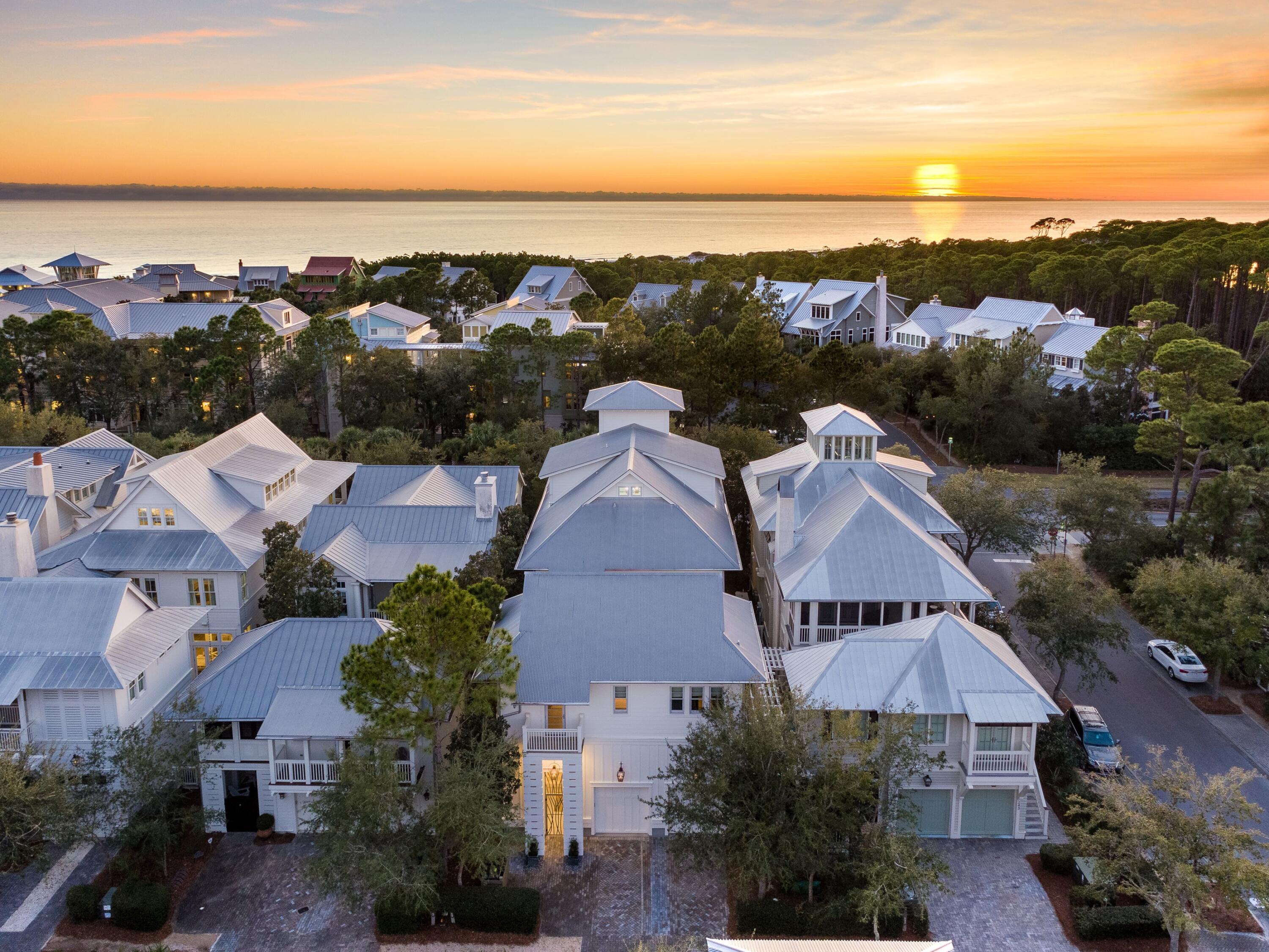 Timeless elegance and luxury await inside this magnificent home and carriage house in beloved WaterColor. Cool whites harmonize with driftwood-finished hardwood flooring while artwork reflects the coastal ambiance embodied in each carefully curated space. Hand-picked furnishings and designer finishes create an enviable living space rarely seen outside the pages of glossy home magazines. Designed by Thurber Architecture, the home encourages an indoor-outdoor lifestyle, flowing seamlessly through a wall of fully opening nano doors to the private courtyard and pool. A grand salon is intended for entertaining yet incorporates an intimate sitting area and fireplace. High clerestory windows add natural daylight to this spectacular open living space. Move into the upscale chef's kitchen where quartz countertops, St. Charles cabinetry and professional-grade appliances are complemented by a frosted glass pantry. Pendular lighting elevates casual dining at the breakfast bar to a higher status for serving evening cocktails and canapes. The interior design successfully mixes and mingles antique-style chandeliers and natural elements with modernist stainless steel handrails on the sweeping staircase. An elevator services the three main floors including the decadent master suite on the third floor with its own spa-like master bath. The top floor is a tower room, specially designed for enjoying stunning views at sunset. Created for multiple generations to share, there's a separate carriage house above the garage for guests to enjoy their own luxurious quarters. A private entrance leads to this delightful pied-à-terre with its own kitchenette, bedroom and full bath. The terrace is a place for relaxing by the pool where azure waters bubble lazily at the foot of a mosaic wall and water cascade. Alternatively, find your own quiet nook on one of the multiple porches spread across all four levels. Beaches, parks and boardwalks are nearby. WaterColor is known for its first-class amenities including a private beach club, Camp WaterColor and gulf-front dining. This pristine home has never been rented out but its location makes it ideal for enticing renters in the high-end rental market. For investors, the property delivers incredible projected income.