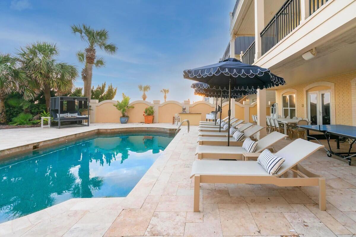 Welcome to Promenade, a stunning Gulf-front retreat in the heart of Miramar Beach where timeless coastal architecture meets elevated design and unforgettable views.

Thoughtfully designed to celebrate its beachfront setting, this seven-bedroom, five-bath residence offers seamless indoor-outdoor living with expansive water-facing patios, double balconies, and a crow's nest overlooking the Gulf and the private pool below. Every level is oriented to maximize natural light, sea breezes, and panoramic views of the emerald coastline.

The private pool invites both leisure and activity -- ideal for swimming laps or cooling off after a sun-soaked day on the sand. Scallop-trimmed umbrellas, a hammock, and shaded lounging areas create a relaxed resort atmosphere, while the modern outdoor fire pit provides the perfect gathering place just steps from the beach.

Inside, the home makes a striking first impression with marble floors, a grand staircase, and a crystal chandelier anchoring the opulent foyer. Spacious living areas flow effortlessly into outdoor entertaining spaces, offering multiple settings for hosting and relaxation. A standout feature is the custom bunk room complete with double bunks, a foosball table, and a smart TV -- a favorite gathering spot for guests of all ages.

Whether enjoying sunset dinners al fresco, morning coffee overlooking the Gulf, or evenings under the stars with family and friends, 747 Scenic Gulf Drive offers the ultimate Gulf-front lifestyle -- a rare opportunity to own a legacy property directly on the sand in one of the Emerald Coast's most desirable locations.