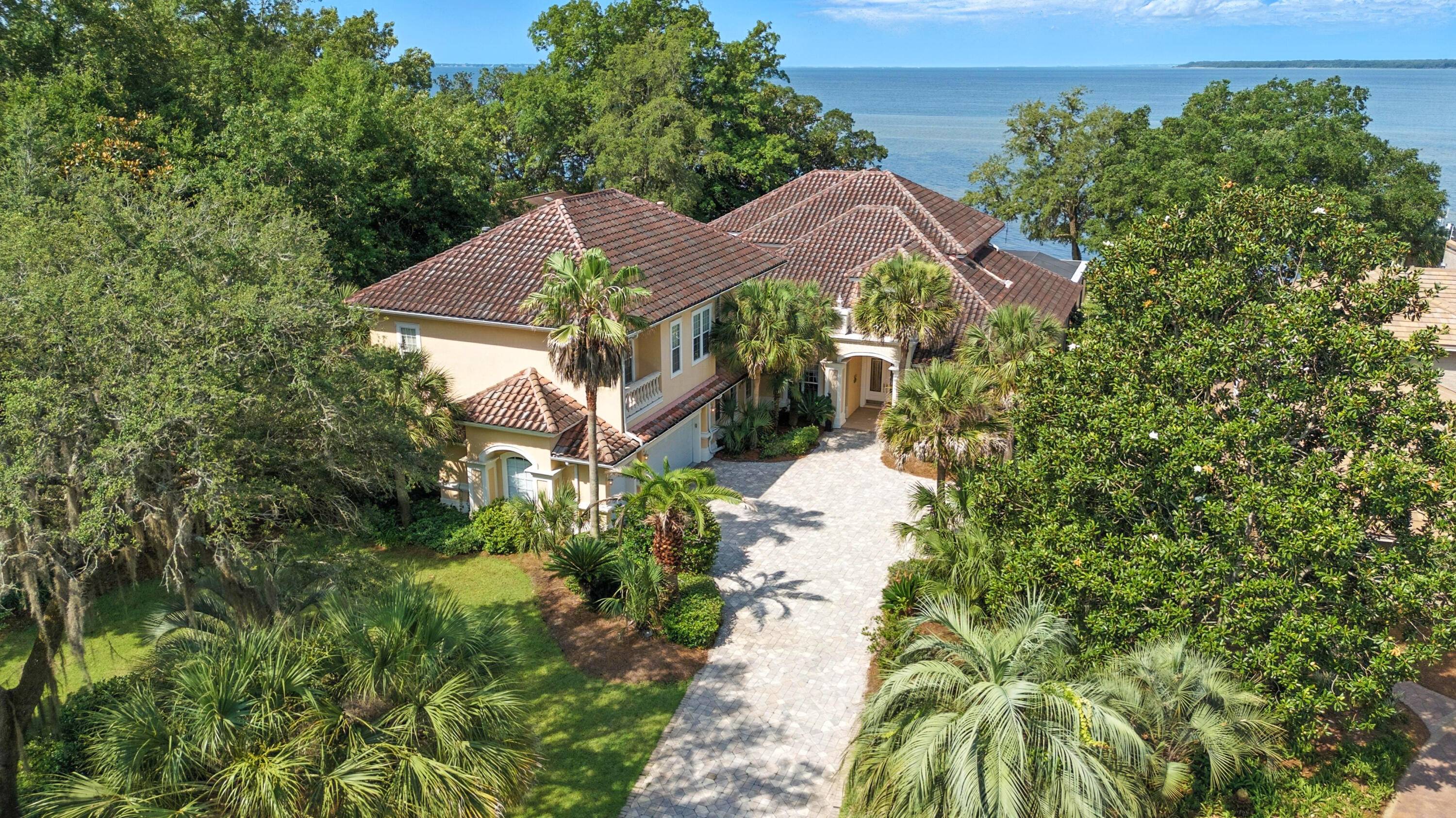 Offered exclusively for the first time, 923 Lido Circle is a rare opportunity to own a masterfully designed, European-inspired bayfront estate in the coveted Bluewater Bay community. With nearly 7,000 square feet of living space and 8,710 total square feet, this home exemplifies elegance, privacy, and exceptional craftsmanship — all set on 100 feet of private waterfront along stunning Choctawhatchee Bay. Built by Maurice Sweet of Tier One Custom Homes, with meticulous German engineering, the home features exquisite European details throughout, from a scroll detailing the home's history encased in a glass-tiled entryway to custom Murano glass light fixtures, imported finishes, and high-end design elements. Each of the seven generously sized bedrooms features an ensuite, providing comfort and privacy for family and guests. A bay front office with a private bath serves as a tranquil work-from-home space with panoramic water views. The chef's kitchen is equipped with premium Miele appliances, including a steamer, wine refrigerator, ice maker, and a refrigerated walk-in pantry, perfect for both entertaining and everyday luxury. Large, open-concept living areas flow seamlessly, creating a layout ideal for gatherings, while still offering intimate retreats throughout the home. Outdoors, a fully enclosed saltwater pool and spa are surrounded by covered patios and balconies, with a summer kitchen complete with food prep and cooking areas. Whether relaxing by the pool or entertaining guests, the outdoor living spaces provide year-round enjoyment with sweeping views of the bay. The property's private party deck extends over the bay, providing a front-row seat to daily dolphin sightings, vibrant sunsets, and colorful rainbows. It's also equipped for boat dockage, offering convenient access to boating and water sports. Additional features include a guest house under beam, oversized walk-in closets, bidets in most bathrooms, solar panels for energy efficiency, and electronically controlled storm shutters for added security and peace of mind. Located in a quiet, upscale enclave of Bluewater Bay, this home is just minutes from the marina, Freedom Boat Club, sailing, water sports, LJ Schooners waterfront restaurant, and a host of recreational amenities, including golf, tennis, pickle ball, community pools, and walking trails. Destin's famed white-sand beachesincluding Crystal Beachare only a 10-minute drive away. The area also offers proximity to top-rated schools, shopping, dining, parks, hospitals, and all the conveniences of the Emerald Coast lifestyle. For the discerning buyer seeking a serene retreat that doesn't compromise on luxury, access, or amenities, this home represents an unparalleled coastal living experience.