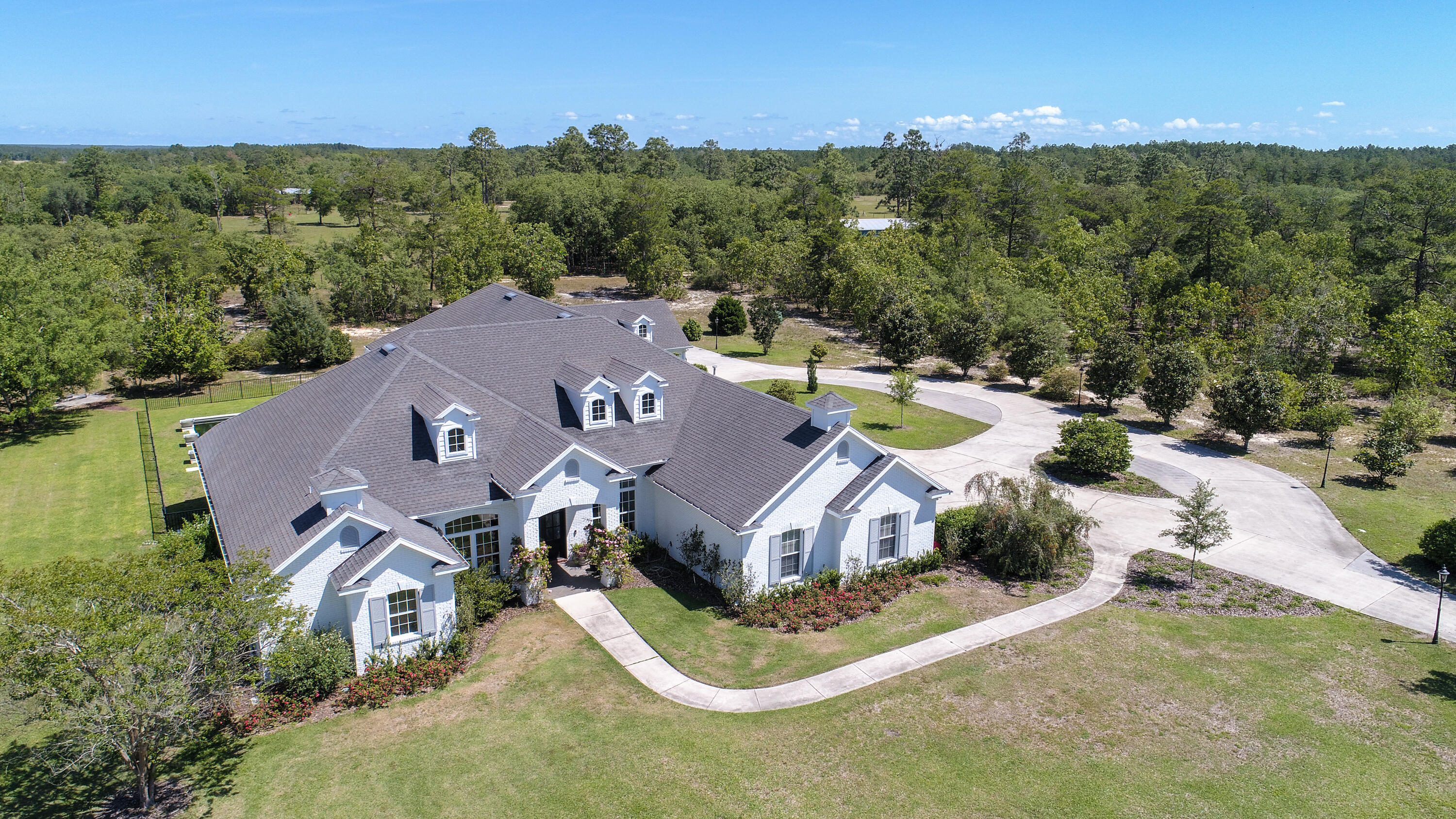 Privacy, amenities and the pinnacle of estate living is embodied at this expansive 4,625 square foot home nestled on 9+ acres in the prestigious community of Windswept Estates. Offering an architecturally significant design and flawless flowing and floor plan for effortless living, this 5 bedroom, 5-and-one-half bath home provides a truly turnkey and fully furnished product ideal for both primary and secondary living opportunities. Fully renovated by Geoff Chick & Associates, British design elements inspire the exterior of the home, while contemporary coastal influence fills the interior with high-end finishes, top of the line appliances, and purposeful natural light. Designed in a split format, multiple living areas are centrally located for true relaxation and gathering opportunities, while the chef's kitchen with 48" Wolf range, marble clad countertops with waterfall island and designer lighting craft an inspirational space to cook or entertain. Showcasing a blend of crisp white walls with formed entries with natural wood ceiling inlays in the central living room as well as the oversized master suite, the balance in each design choice is something meant to be experienced.

Transitional spaces were placed as high priority, offering plentiful opportunities for outdoor living and dining around the newly constructed gunite pool with limestone surround and enchanting water features. The white painted brick exterior creates a fresh feel to the classically inspired architecture, while two separate two-car garages provide plentiful space for storing vehicles, golf carts and beach toys.

Located within the 450-acre master planned development of Windswept Estates, this 5-star golf community provides a meticulously designed community less than 15-miles from the sugar white sand beaches of South Walton County.