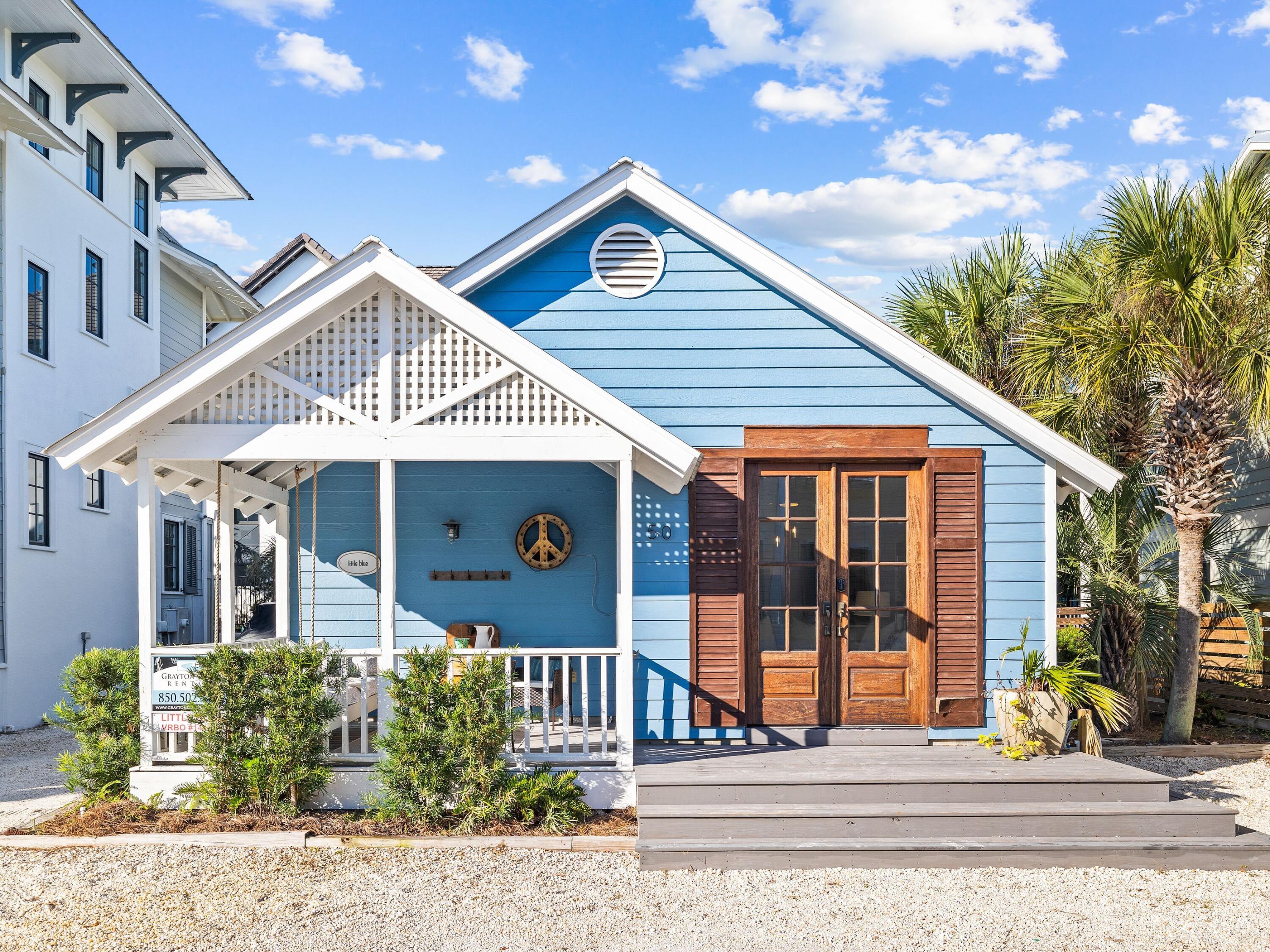 UNDER CONTRACT, ACCEPTING BACK UP OFFERS.  Welcome to ''Little Blue'' on famous Grayton Beach!  Filled with charm, this characterful beach cottage is nicely updated and comes with its own private yard oasis. Beach fans, and savvy investors, will love the LOCATION just one back from the white sand and emerald waters of Grayton Beach. Laid out on one level, the cottage is surrounded by shady palms and has its own private parking pads at the front and side. Steps lead up to the front porch which tempts you to pause awhile and enjoy the alluring gulf and lake views from the cushioned swing seat. Double doors with shutters lead inside to the open sitting room with hardwood flooring. The soaring vaulted ceiling adds light and space to the laid-back ambience with shafts of sunlight pouring in  through windows and French doors.  Four stools are lined up at the bar ready for brunch or cocktails, depending on the hour. The surprisingly spacious eat-in kitchen is well-equipped with white cabinets, stainless appliances and generous countertop space. Doors lead off to two cozy bedrooms, a modern bathroom and a half bath. Head outdoors through the rear porch, passing a stackable washer/dryer on the way. The delightful rear yard has a shady deck for alfresco living and dining in your own peaceful oasis. Large pavers create a footpath through the low-maintenance landscaping to the grilling area and outdoor shower. After dark, gather around the fire pit with family and friends, socializing and toasting marshmallows in the glowing embers. More than just a beach retreat, this is a place for memory-making in a highly sought-after location. It's within strolling distance of the popular Red Bar, restaurants and shops. The cottage is in a prime area for vacation rentals and could be replaced with a new construction home in the future. It comes with a neighborhood pool shared with a handful of neighbors as the cherry on top.