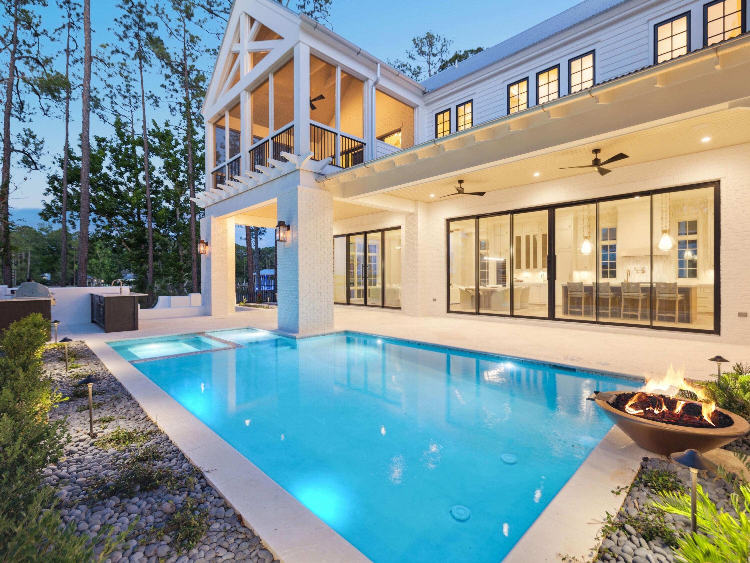 Framed by sweeping views of Churchill Bayou, the home offers a front-row seat to stunning sunsets and the serene rhythm of the water, visible from multiple vantage points throughout the property, including the main living area, primary suite, and expansive porches. Set within the exclusive gates of Churchill Oaks and with the option to purchase a 35-foot boat slip, this newly constructed two-story home embodies refined coastal living with timeless architectural style and upscale finishes throughout. Spanning more than 4,000 square feet, this four-bedroom, four-and-a-half-bath residence sits on a private 0.2-acre lot, thoughtfully designed to combine elegant comfort with seamless indoor-outdoor living. Inside, you're welcomed by a sun-drenched interior showcasing soaring beamed ceilings, expansive windows, and beautifully curated finishes. The heart of the home is the chef's kitchen, outfitted with custom cabinetry, quartz countertops, and professional-grade appliances. A generous center island anchors the space, ideal for entertaining, and flows seamlessly into a bright open-concept living and dining area with a cozy fireplace and tranquil views. The first floor features a serene guest suite with a spa-like bath and walk-in closet, while the primary and additional suites upstairs each offer private ensuite baths. Multiple covered porches and a private backyard oasiscomplete with a sparkling poolinvite year-round enjoyment under the pines. Set among the natural beauty of Churchill Bayou, Churchill Oaks offers a lifestyle unlike any other. Oak-lined streets, lush landscaping, and peaceful privacy define the community, while resort-style amenities elevate the experience. Residents enjoy access to a bayfront clubhouse, state-of-the-art fitness center, swimming pools, and a deep-water marina with 36 private boat slips. This is a rare opportunity to own in one of the most sought-after communities on 30A  where nature, design, and waterfront living converge.