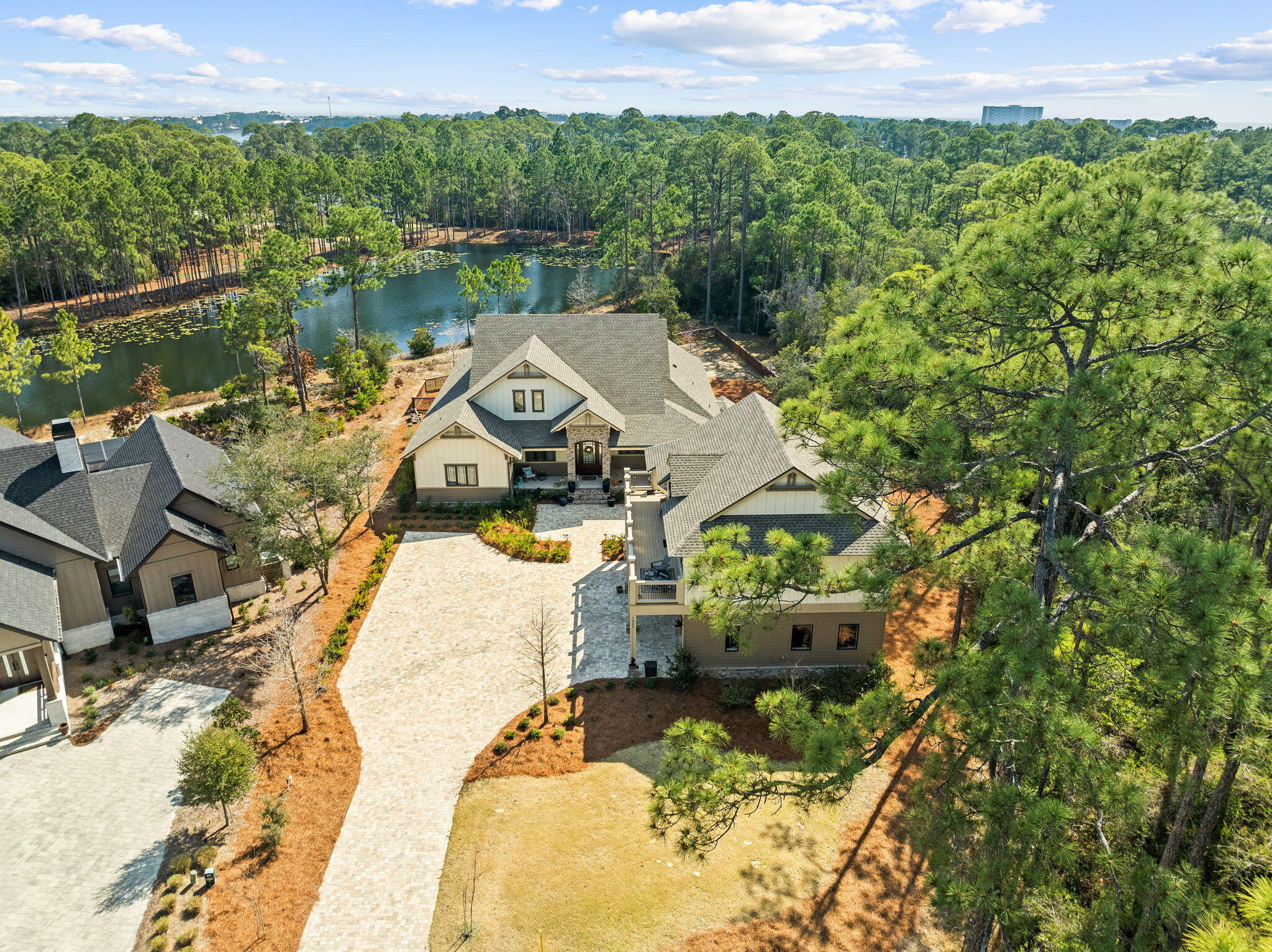 Welcome to 1400 Otter Point, a rare opportunity to own one of the most exceptional properties in the prestigious, gated Wild Heron community—nestled along the shores of Florida's largest coastal dune lake, Lake Powell. This luxurious coastal craftsman estate sits on an oversized, private lot with serene pond views, blending refined design with resort-style living. Step inside to find a custom-designed kitchen that will impress even the most discerning chef—complete with top-of-the-line appliances, exquisite cabinetry, and an elegant island perfect for entertaining. The expansive living areas flow effortlessly to the outdoors, creating a seamless connection between indoor sophistication and outdoor enjoyment. The primary suite offers a peaceful retreat with a spacious spa-inspired bath and and a large custom walk-in closet designed for luxury and functionality. Guests will love the carriage house with a 3-car garage, offering versatility and privacy for extended stays or a studio space. Outdoors, the property transforms into an entertainer's dreamfeaturing a fully equipped outdoor kitchen, covered living space, and tranquil pond views surrounded by lush, mature landscaping. Located in one of the Emerald Coast's most sought-after gated communities, residents of Wild Heron enjoy access to Lake Powell, resort style amenities, and the best of coastal luxury living on the west end of Panama City Beach. 1400 Otter Point is not just a homeit's a lifestyle of elegance, comfort, and privacy.