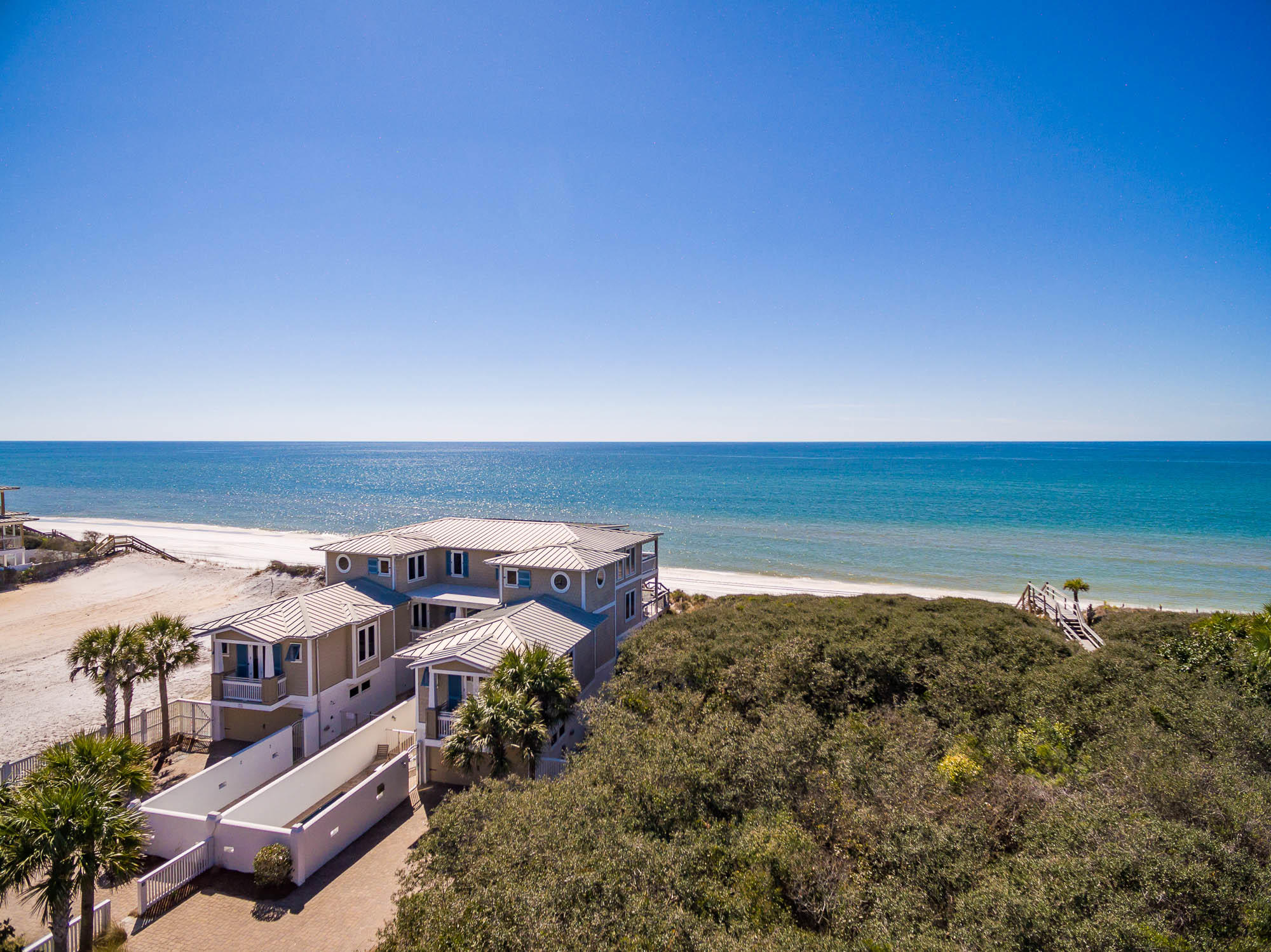 Prominently poised on 75 feet of Gulf-frontage on a private gated road, on the popular east end of the Scenic Highway 30A corridor is this exceptionally large Gulf-front beach house, ideal for quintessential beach gatherings. This exclusive investment property is one of the top-performing vacation rentals along our coast, with an impressive established annual rental income history of over $385,000 and trending to over $395K! The high elevation affords breathtaking panoramic Gulf views. Enjoy the luxury of walking directly from your deck onto the white sands via your private beach walkover, extending from the second level deck. The gated community boasts a prime location, just east of WaterSound Beach and just west of Alys Beach and Rosemary Beach. Offered fully furnished, this 10-bedroom 10 bath property includes an elevator on each side, two 2-car garages, two sizable driveways, and two gated, heated pools The first level offers 6 bedrooms, 4 baths, 2 living areas with kitchenettes, and access to both courtyard enclosed pool areas. Continuing upward, the second level houses the main living areas of the home, boasting ample windows and stunning Gulf views. Here you can enjoy endless sights of the Gulf from the spacious balcony, living areas or dining rooms. The open floor plan is ideal for entertaining and includes two, luxurious kitchens, both equipped with stainless steel appliances, wine chillers, and large center islands with ample seating. The spacious dining areas open on both sides to the expansive deck that adjoins in the center leading to the private beach walkover. Two master suites occupy the full third levels featuring boundless views of the crystal clear Gulf waters. This highly desirable 30A locale provides matchless seclusion while remaining near to the bustling 30A communities, award-winning restaurants, local shops, art galleries, and entertainment. You have the unique enjoyment of a quiet and relaxing beach lifestyle with all of the action minutes away! Discover a special opportunity to own the ultimate beach house on 30A.