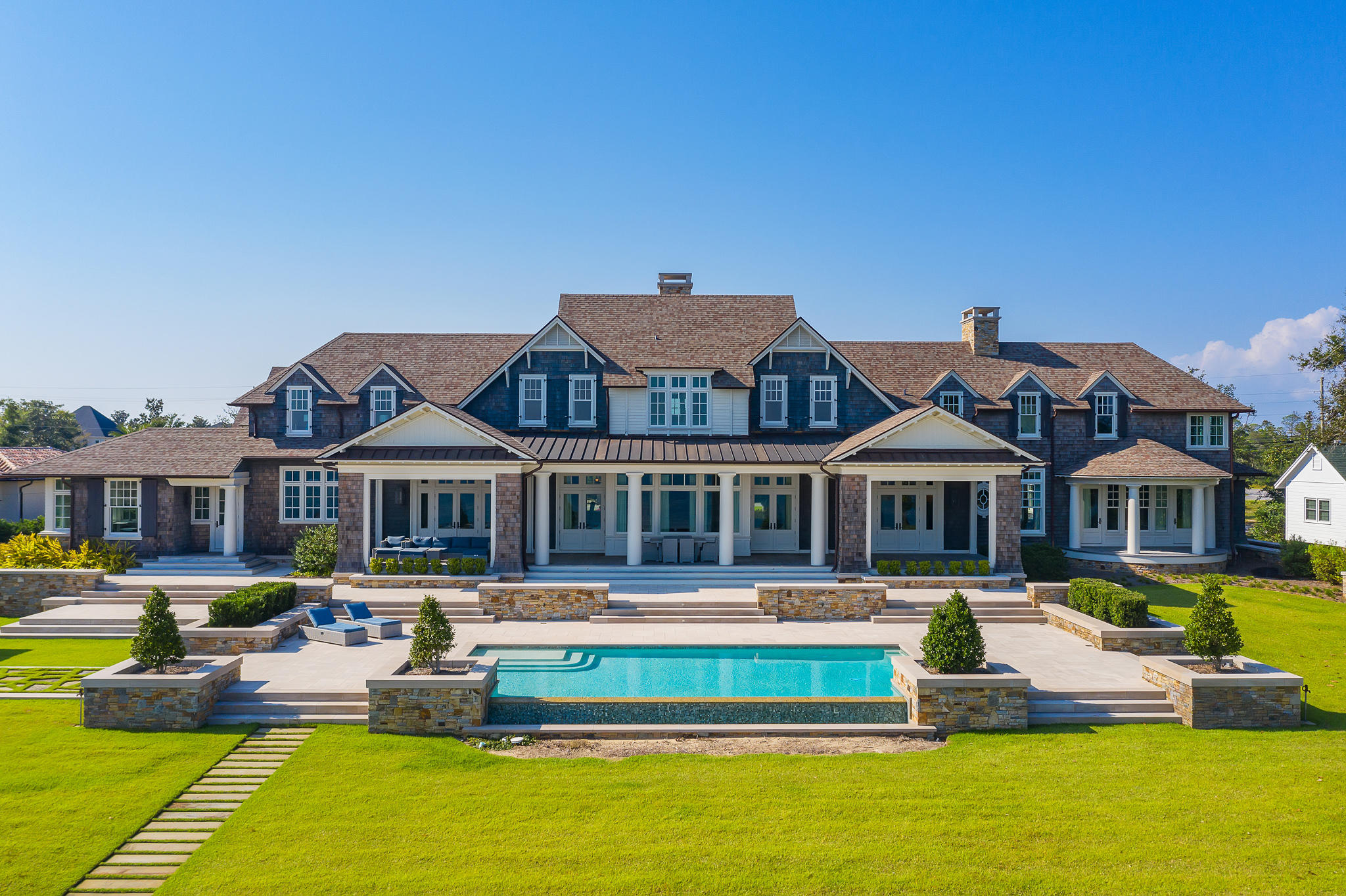 Reigning over 3.1 acres, this impressive Hamptons style edifice sprawls along 200+ feet of Bay frontage framed by both the historic St. Andrews Bay and the lush picturesque vegetation present throughout the estate. A true architectural masterpiece executed by the sought-after architect Eric Watson and builder Clifford C. Myers of Macintosh Myers Construction. The optimal balance of both common and intimate areas is achieved in the 21,000 square feet of highly articulated living space spanning three cohesive levels interconnected by both grand staircases and elevator. The estate is geographically poised within close proximity to the famed Shell Island and Gulf of Mexico pass by boat along with the world-class dining and entertainment venues found throughout inland Panama City Beach and 30A. The kitchen is a chef's dream featuring custom cabinetry hand crafted by Morgan Creek, marble countertops, and separate serving pantry. The backyard is synonymous with relaxation; take a dip in the saltwater infinity pool overlooking the Bay or catch a tan on the private white sand beach with room to add a 150'+ dock. The one-acre parcel to the West of the main home is an extenuation of the estate providing additional parking and storage in addition to a four-car garage with workshop and fully equipped kitchen. Notable accommodations include a private helicopter pad, seven-car garage, geothermal heating and cooling system, whole home automation system, state of the art theatre room, commercial grade generator, and a safe room with dedicated communications. Inquire today to schedule a private viewing.
