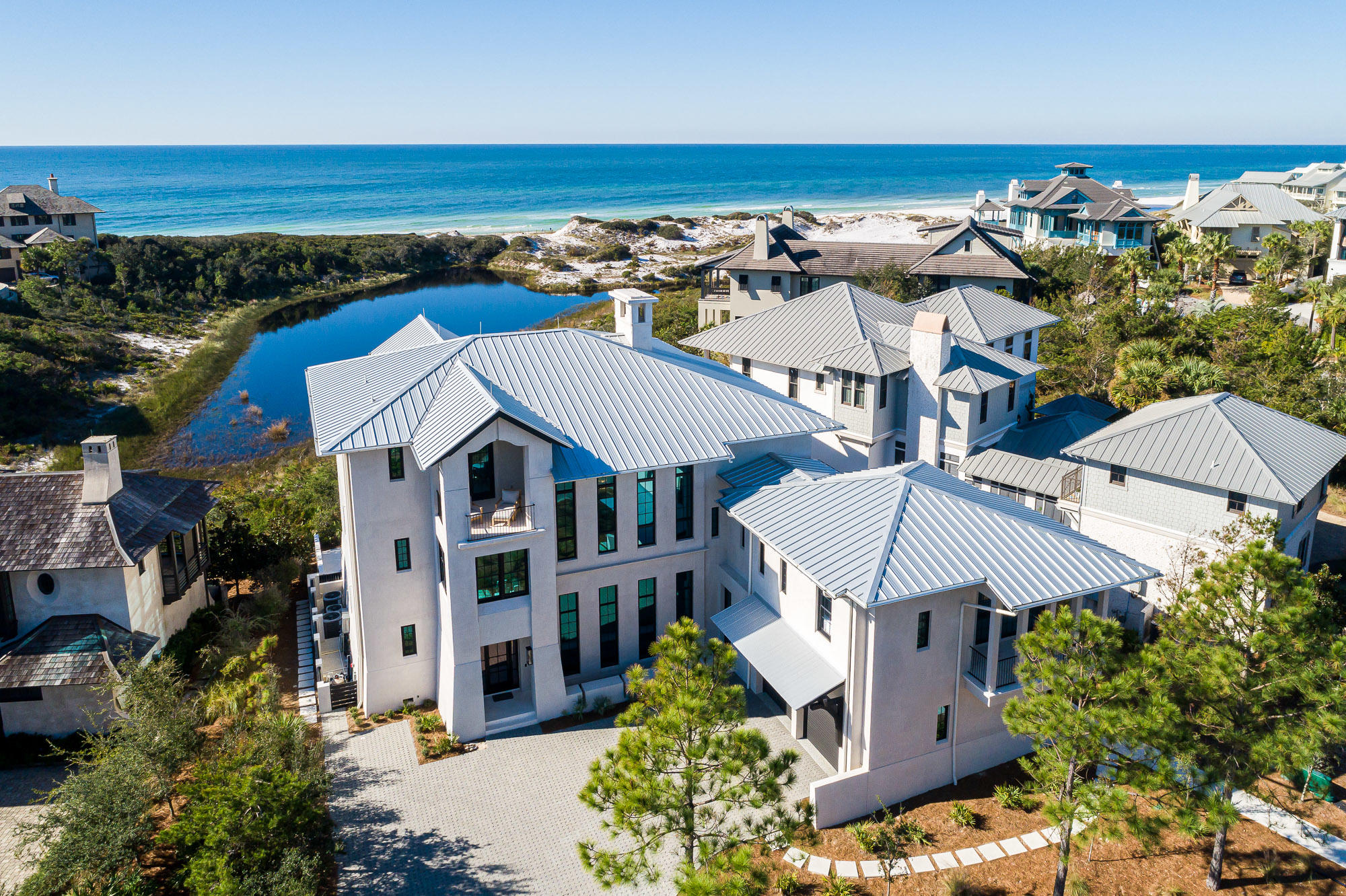 Introducing a true legacy home, poised on a uniquely special, coastal dune lake-front site within The Retreat. This impressive, newly constructed, private lake-front luxury residence, overlooks Draper Lake and the Gulf of Mexico.  Precise attention to design and construction detail has been given by acclaimed architect Matt Savoie and reputable builder Buster Woodruff in creating one of the most majestic residences among South Walton's scenic paradise. The home conveys fully furnished, with interiors just recently appointed by interior designer Georgia Carlee. A coastal retreat for the ages with four spacious levels encompassing 7 bedrooms, 8 full bathrooms and 3 half bathrooms. This home presents a timeless style of comfortable elegance & spaciousness with just under 7,000 square feet of conditioned space with elevator.  Upon entering the home, you are greeted in the foyer with a grand chandelier above and rich oak flooring with Alabama marble inlayed.  The main living area offers a 25' cathedral ceiling, and floor to ceiling windows facing the Gulf allowing an abundance of natural light throughout.  Step out onto the spacious porch, appointed with an outdoor living and dining area, to enjoy tranquil lake and Gulf views. Also on the main living floor, one can find the media room adjacent to the main living room, as well as a private office space.  The gourmet kitchen features Wolf and Sub-Zero appliances with custom cabinetry and an extraordinary waterfall style kitchen island made from rare 5cm marble.  The kitchen comes complete with a generous walk-in pantry and built-in butler's pantry with full size wine fridge.   Spacious guest quarters, with separate living area, bedroom and private bath, are also accessed from the main living floor.  The top floor exclusively houses the master suite featuring his and hers bathrooms, custom designed walk-in closet and coffee & wine bar.  Vaulted oak ceilings paired with floor to ceiling windows flood the room with light and warmth.  Start your day off right by sipping your coffee on the private balcony off the master suite while watching the deer stroll around the lake all while overlooking the Gulf.  Four sizable guestrooms are located on the second floor.  Each guestroom features a luxurious private en suite, and lake-front and Gulf views, along with private door to the Gulf facing porch for convenience.  The lower level houses a six bed bunk room and full bath as well as a secondary laundry room.  It also features a large full kitchen and bar as well as a living area that leads out to the heated, salt-water pool and patio.  Enjoy lounging poolside or in the pool on the sun shelf while keeping cool.  This luxury residence truly has it all.   Elevated on one of the most desired homesites within the community, this home boasts stunning views with rolling dunes of both Draper Lake and the Gulf.  The community amenities include a beautiful Gulf-front pool deck as well as a community dock on Draper Lake.  The Retreat boasts an exquisite setting and an extremely quiet and private beach, which has become a rare and coveted find along the highly demanded Scenic Highway 30A corridor.  Discover the rare beauty of luxury coastal living in The Retreat.