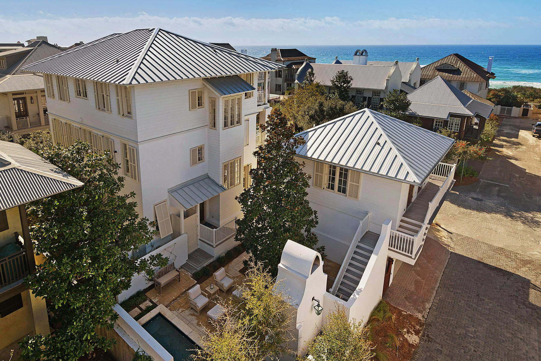 Experience life in Rosemary Beach as only a few can in this recently renovated gulf view home and carriage house, south of Scenic Highway 30A, and only a stone's throw from the trend-setting shops and divine dining establishments along this famed new urban town's Main Street. Located directly on a beach boardwalk, the home's position takes advantage of unusually wide setbacks of the homes immediately across the street along the waterfront. This unique scenario affords its third floor living spaces panoramic views of the Gulf of Mexico's emerald waters. A thorough renovation of the outdoor courtyard space includes a striking outdoor fireplace, outdoor shower, and dipping pool with fountain. Their crisp white stucco and stone finishes are softened by maturing foliage, creating a contemplative space to relax in. Renovations continue indoors, reflected in the pristine baths, kitchen, and flooring. Gulf views can even be enjoyed from the master suite, offering access to wrap around balconies, found on each floor.