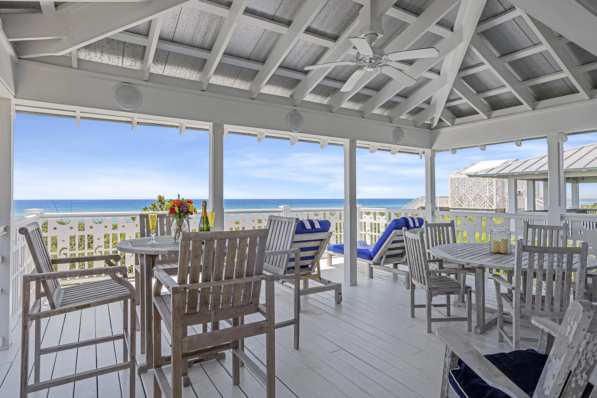 Proudly positioned Gulf front, is this lovely shingle-style Craftsman cottage designed by Richard Gibbs, who once served as Seaside's Town Architect. This charming beauty rises two stories above the snow-white dunes and is snuggled by care-free native oaks. The tabby chimney with exposed oyster shells is a unique feature of this Seaside cottage. An outdoor shower with rain-style shower head and accompanying storage room for beach toys are conveniently located adjacent to the entryway. Upon entry, three bedrooms- each with ensuite baths, are located on the first level. The charming master suite offers a cozy fireplace for chilly nights, and an adjoining 20' x 20' screened porch for those quiet times with either a good book or to sneak in a quick nap.  The baths were designed with playful tile and fish sinks from MacKenzie-Childs. A coffee bar, laundry room and owner's walk-in closet are also located on the lower level. Handmade tiles from Pratt and Larsen were used throughout the cottage. The staircase, running through the cottage's central core to the second floor, is embellished with whimsical cut-out details such as dancing dolphins, and were a custom design by the original owner for the exterior rails, stairs, and ceiling of the second level. Kitchen, dining, and living rooms all flow seamlessly into the other, creating open spaces which are so popular. The beautiful kitchen countertops are made of cherry wood and trimmed with Pratt and Larsen tiles. Other details that set this beach home apart from others are-  a cypress cabinet at the rear of the great room crafted by a local cabinet maker; a bunk room with bath which is tucked behind the great room; and the ten foot herb-drying table which had been refurbished and serves as the dining table with seating for eight, are a few examples.  Heart pine floors throughout the house came from old-growth logs harvested locally at least a hundred years ago, and a custom-made cypress mantle adorns the fireplace. Interior doors were milled from reclaimed old wood. But for the grand finale- the 20'x20' covered porch which serves as your outdoor great room overlooking the emerald waters of the Gulf of Mexico- from east to west as far as the eye can see! Carport for two automobiles is included.