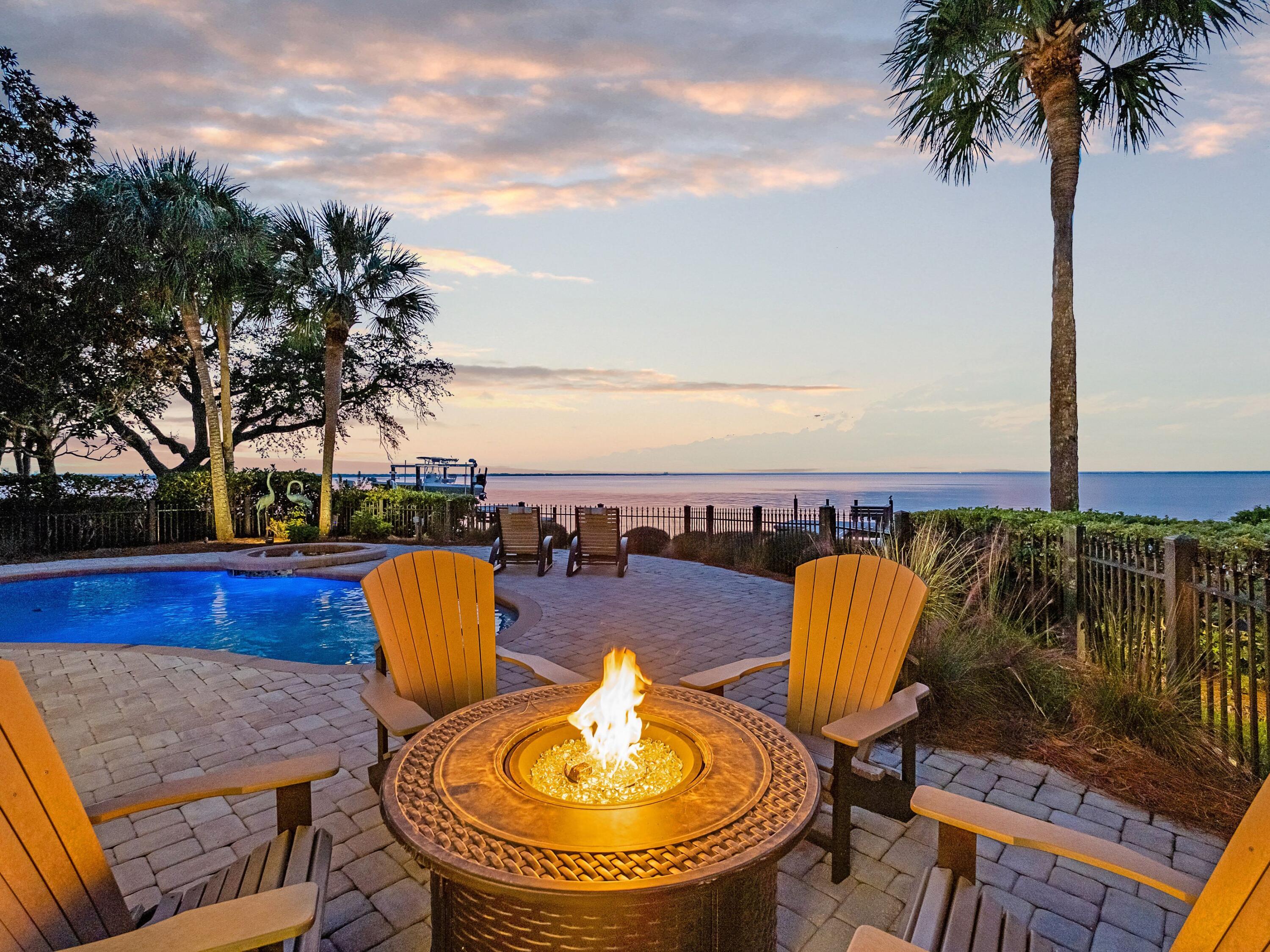 This Burnt Pine property has plenty to boast about with its stunning bayfront location, private pool, hot tub and great outdoor space for entertaining. Surrounded by landscaping and shady palm trees, this single-story home makes the perfect sunshine retreat. A long pavered driveway leads to a two-car garage, separate golf cart garage and glazed entrance porch. Recent renovations have created a stunning living and dining area with a gas fireplace and the adjoining kitchen is sublime. It features new cabinets and counters, a Wolf range, Sub-Zero fridge and ice maker, ensuring a steady stream of chilled drinks is always on hand. Three spacious bedrooms are complemented by newly updated bathrooms and there are opportunities for new owners to add their own personal touch.