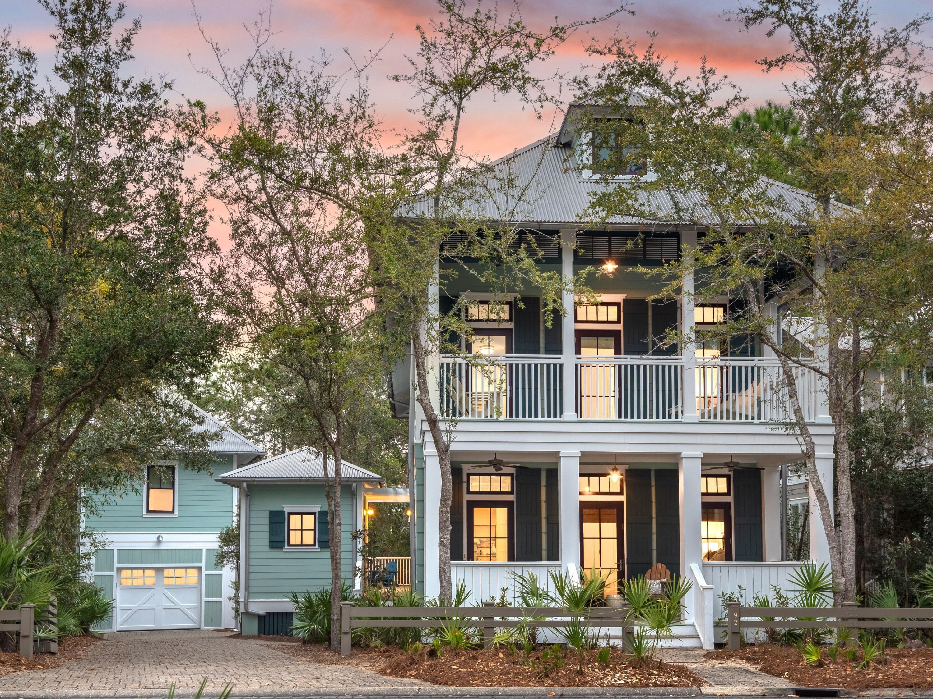 Recently renovated to the highest standards, this Southern-style home has shady, covered porches on both levels. Backing on to preserve land with mature pine trees, it enjoys a sense of privacy yet is just two blocks from Camp WaterColor fun. The open-concept living space has dark wood effect flooring countering the high ceilings, white decor and transom windows delivering an abundance of natural light. The chef's kitchen has been beautifully updated with a full range of stainless appliances and a beverage bar. Quartz countertops extend over the generous island which easily accommodates five diners at the breakfast bar and overlooks the cozy living room completed with fireplace. Dine at the formal dining table or outdoors on the deep screened porch. It boasts a pleasant outlook onto permanent green space with steps leading down to the rear yard and neighboring carriage house. Five bedrooms, all ensuite, include a bunk room and a spacious master suite with twin vanities, a free standing garden tub and tranquil tree-top views. The second-floor balcony even has a swing for lazing away the days with a good book or snoozing after lunch. The independent carriage house includes a tastefully appointed sitting room with shiplap walls, a fully equipped kitchen and a bedroom and bath above the two-car garage. It even has a deck for guests to enjoy their own outdoor space, relaxing in the breeze. Within easy reach of WaterColor pools, parks, trails and amenities, this turnkey home is ideal for investment in this sought-after location. Fully furnished, recently updated and immaculately presented, it has a proven history for vacation rentals, generating more than $239,000 annually.