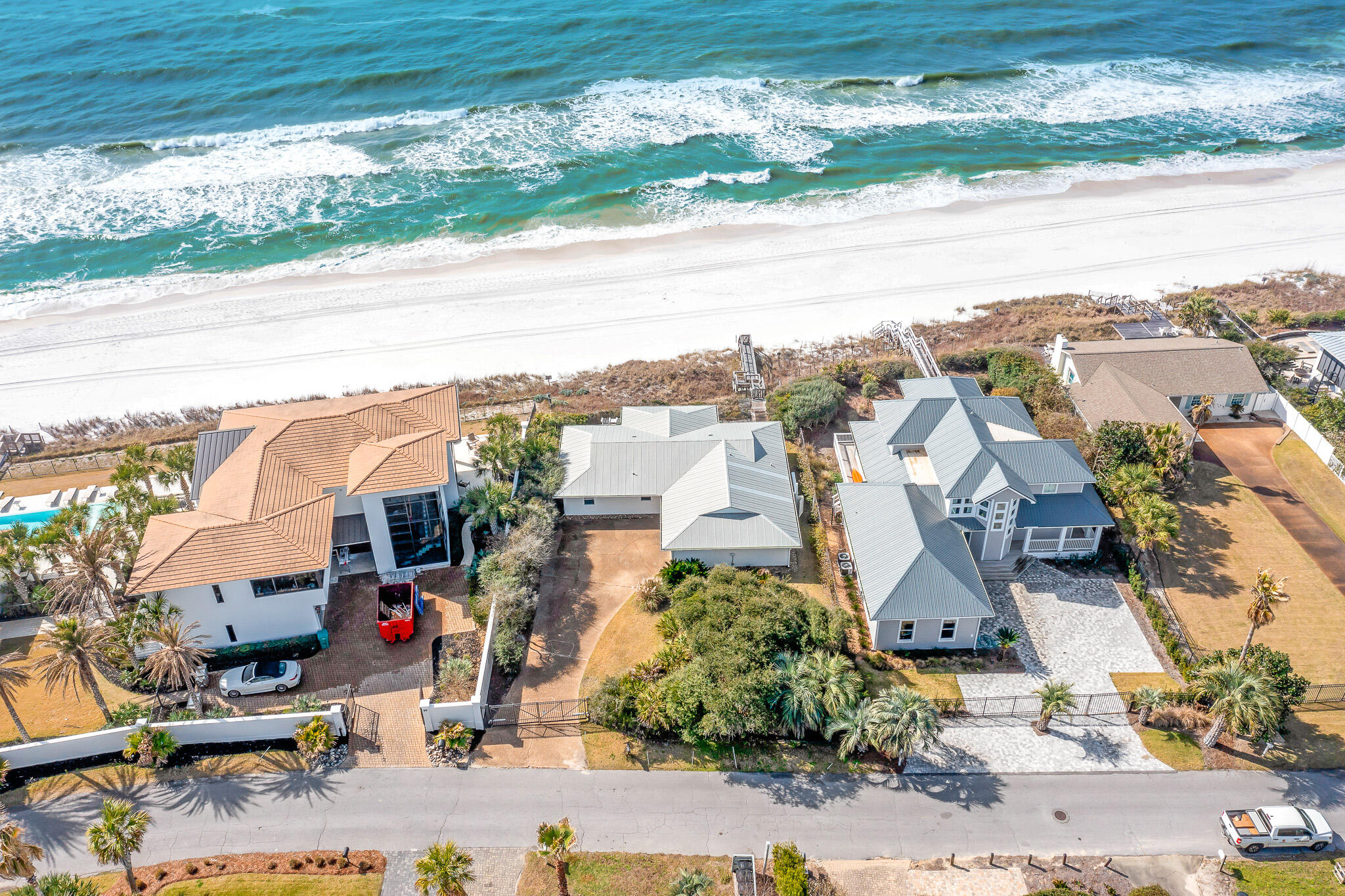 Spanning 76 feet of Gulf-frontage on 30A's popular east end, this charming beachfront home is poised in the gated community of Pelican Pointe.  The gulf-front community of Pelican Pointe directly neighbors Camp Creek Lake, and offers a uniquely quiet setting, while just a short walk or bike ride to the bustling town centers of Alys Beach, Rosemary Beach, and Watersound.  The residence is gated, offering an additional layer of privacy.  Escape to your coastal paradise on this private, deep homesite boasting an expansive beach frontage and stunning Gulf views. The coastal lifestyle of the sought-after east end of 30A cannot be matched, and you will enjoy the sanctuary location while being only a walk or bike ride to the liveliness of the popular planned communities of Alys Beach and Rosemary Beach. Seclusion and serenity meet coastal luxury living at 71 Pelican Circle. Upon entering, you are greeted with an open living area and kitchen, a design suited for comfortable gathering, while looking out upon the white sands and emerald waters. Floor-to-ceiling glass sliding doors span the south side of the home, opening to flaunt panoramic Gulf views, from the privacy of a fenced-in sun deck that steps out to the Gulf via your beach walkover. The primary suite, along the west side, provides access to the Gulf-front deck, as well as picturesque and calming Gulf views. A laundry room and half bath make up a mudroom that allows for ample storage and ideally exits via a door the the outside shower. Two spacious guest bedrooms, with shared bathroom, allow for privacy, aligning the east side of the home. Priced to sell, this Gulf-front home site provides a unique opportunity to enjoy the well-kept charming cottage or to build a large dream home on a sizable site.