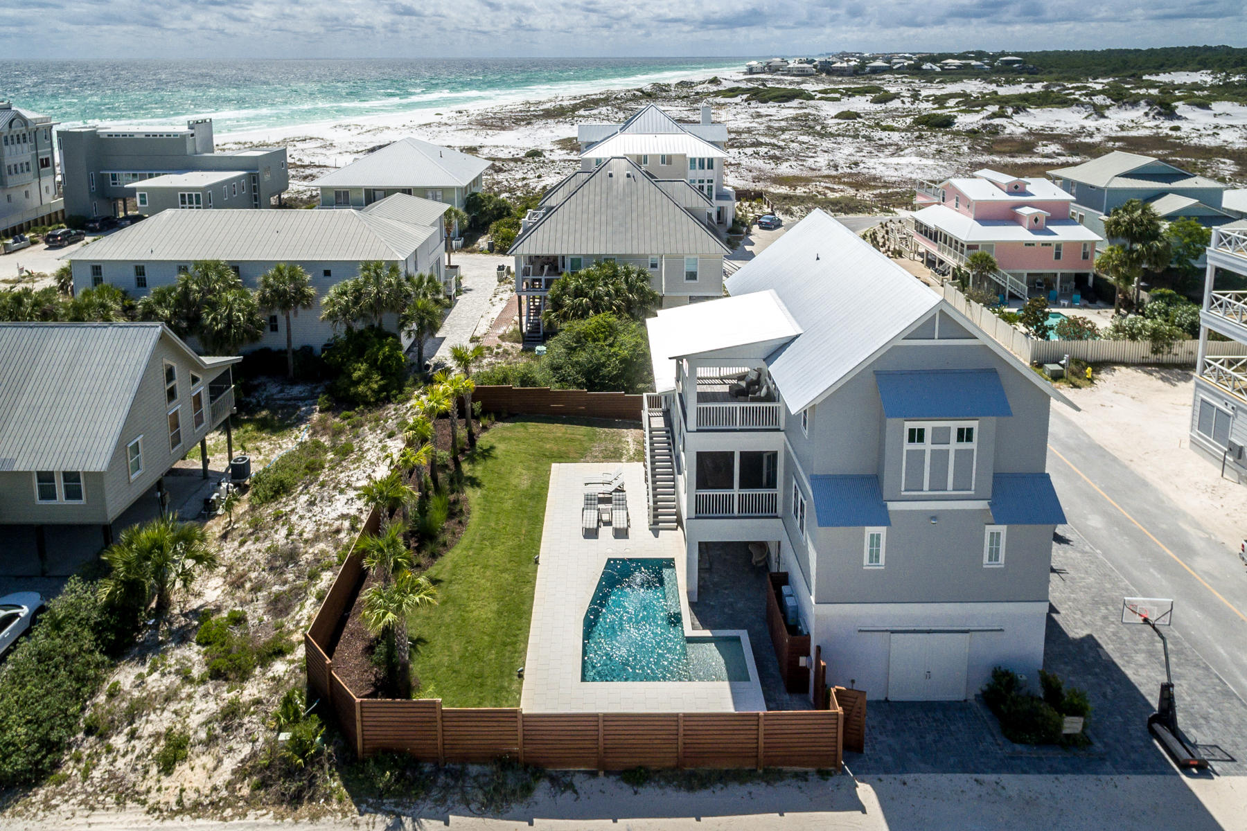 Stunning home in historic Grayton Beach with a private pool, expansive backyard, gulf views and just steps away from the beach. Located on a 100' x 100' lot, the main house (built in 2018) boasts 4 bedrooms, 4 full and 2 powder baths, as well as a recently completed fully-contained first-floor apartment with a kitchen, quartz countertop, living area, bedroom, bath and separate side entry. This gives the home an ideal configuration of 5 bedrooms, 5 full bathrooms and 2 powder baths. The open concept kitchen and living room are located on the second floor and opens to a 12' deep screened porch that runs the full width of the home, perfect for dining al-fresco. Enjoy a chef's kitchen with a farmhouse sink, marble countertops, 48'' Wolf 6 burner gas range, ice maker, SubZero refrigerator freezer and 18" wine fridge. No detail was overlooked in this Stackable-Mracek designed and Corestruction built home including saw-cut hardwood floors throughout, custom barn doors, wood beams in the living room and kitchen, speakers wired throughout the living room, kitchen, porches, pool area, master bedroom and bathroom. Two guest bedrooms are located on the 2nd floor, both with en-suite baths. Enjoy gulf views from the spacious third floor master suite which includes a vaulted ceiling, his and her vanities, a spa-like shower and large walk in closet. Celebrate each "Grayt" day from the private porch off the master bedroom with views of the Gulf of Mexico and Grayton Beach State Park. The bunk/media room with an en-suite bath completes the third floor and includes built in bunk beds, desk area and a additional room for a game or media area. This home offers abundant parking plus a 2-car garage. Home is sold fully furnished with a few minor exclusions. Grayton Beach, often revered as the original beach community, is nestled between a nearly half mile stretch of protected beachfront to the west, and another one mile stretch to the east, both of which are part of the Grayton Beach State Park system. This intimate beach community is home to The Red Bar, one of the most iconic destinations along Scenic Highway 30A. Along the eastern boundary of Grayton Beach is Western Lake, one of Northwest Florida's naturally occurring coastal dune lakes.
