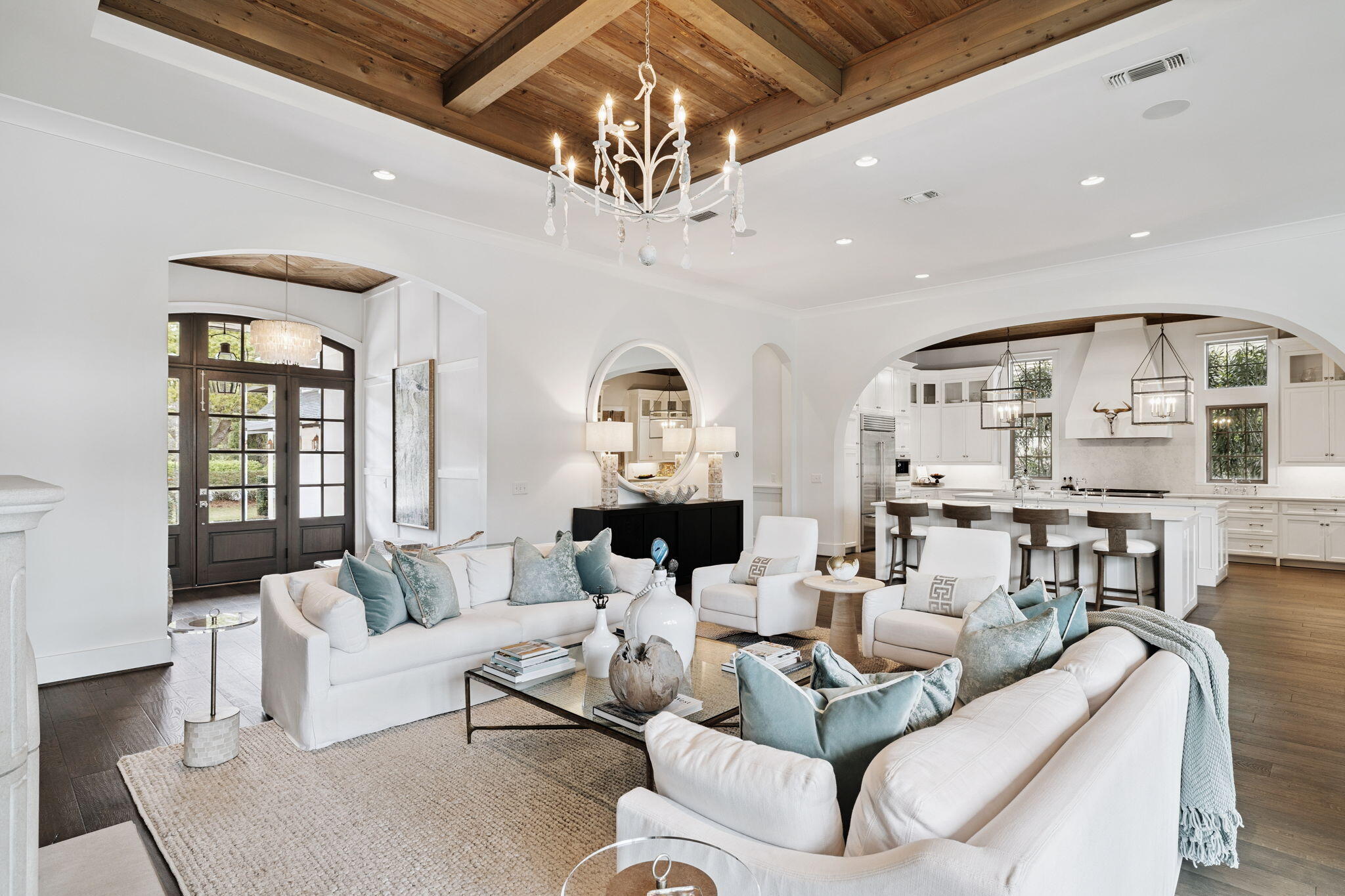 Located in the gated community of Regatta Bay, this custom residence was built by DeBogory and Vlahos Construction and designed by Bob Chatham Custom Home Design. The home blends timeless coastal architecture with thoughtful design and quality craftsmanship throughout. Inside, the open floor plan is defined by 12-foot ceilings, arched openings, and pecky cypress accents that bring warmth and character to the main living spaces. The living room, centered around a gas fireplace, flows effortlessly into the kitchen and dining areas, creating a space that feels both open and inviting. Expansive views of the lake and outdoor living area create a seamless indoor-outdoor connection and a calming backdrop throughout. The kitchen is designed with both entertaining and style in mind, featuring dual islands, Wolf and Sub-Zero appliances, and a spacious walk-in pantry with reclaimed wood doors. Just off the main living area is a walk-in wine cellar with capacity for 280 bottles. The first floor includes the primary suite along with three additional guest bedrooms, allowing for true first-floor living. Privately positioned on its own wing just off the living room, the primary suite features a coffered ceiling and sliding doors that open directly to the patio and pool. The primary bath is finished with Italian marble, dual vanities, a soaking tub, and a walk-in shower. Upstairs, you'll find two additional guest bedrooms, each with ensuite bathrooms and access to a covered porch overlooking the pool and lake. A large walk-in storage closet is located at the end of the hall. Outdoor living is designed for both relaxation and entertaining, with a spacious screened porch featuring a wood-burning fireplace, outdoor grill, and a private heated pool with a sun shelf. A private dock overlooks the water, offering a peaceful setting to unwind. Speakers are installed throughout the main living areas, covered patio, and outdoor spaces. Regatta Bay offers a central Destin location with convenient access to Destin Commons, Legendary Marina, and the white sand beaches of the Emerald Coast, all without the need to travel along Highway 98. The community features an 18-hole championship golf course, clubhouse with dining and social events, pickleball and tennis courts, a community pool, and multiple lakes for fishing. The Destin Harbor is just a short drive away, known for its waterfront dining, entertainment, and boating lifestyle. ** Buyer to verify all information **