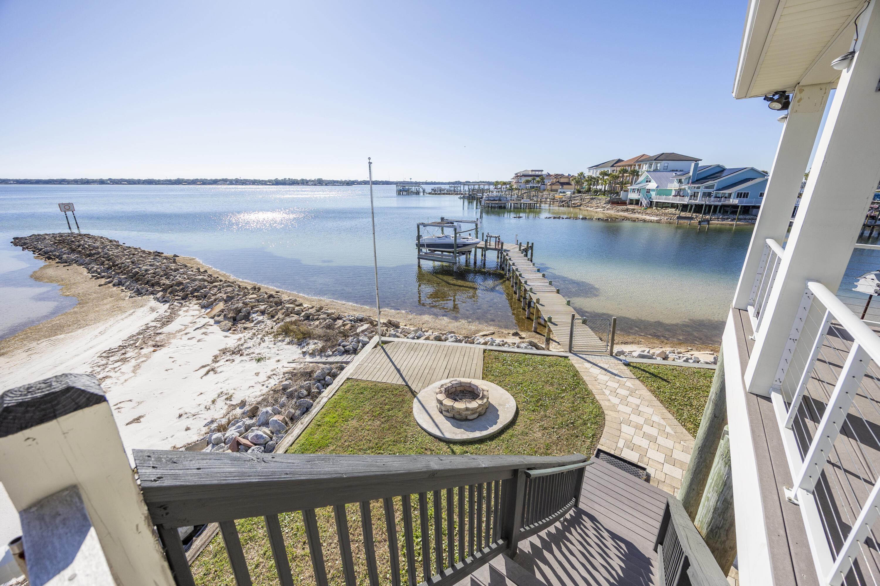 Rare opportunity to own a true waterfront retreat with a private beach, private dock, and jetty—not just waterfront access.  Dock includes a fully operational boat lift and 240V electrical service that was added in 2023.  This 3bed/2 bath home has been thoughtfully and extensively updated since purchase. The kitchen features new stainless steel KitchenAid appliances, a remodeled pantry with doors and soft-close expandable shelving, an in-wall microwave/oven combo, and a newly installed hood over the range.  Bedrooms feature new LVP flooring, and the primary suite offers dual closets with custom built-ins. Bathrooms have upgraded lighting and fixtures, and the primary jacuzzi tub is fully functional with new motor and components.  Additional interior upgrades include a designer dining room light fixture imported from Europe and a custom built-in entertainment center in the living room.  Outdoor living has been completely transformed. The front yard was fully remodeled with desert-style landscaping, white pebble accents, new mailbox and front pillars, and a newly constructed cement wall.  In the backyard, repairs were made to walkways, and a permanent cement block firepit was added.  HVAC system replaced August 2025.  Seller may include an 18' Hurricane deck boat with 150HP Yamaha outboard and trailer, offered as-is, or sell separately.  This property blends modern updates, outdoor living, and premier waterfront amenitiesan ideal primary residence, vacation home, or investment opportunity.