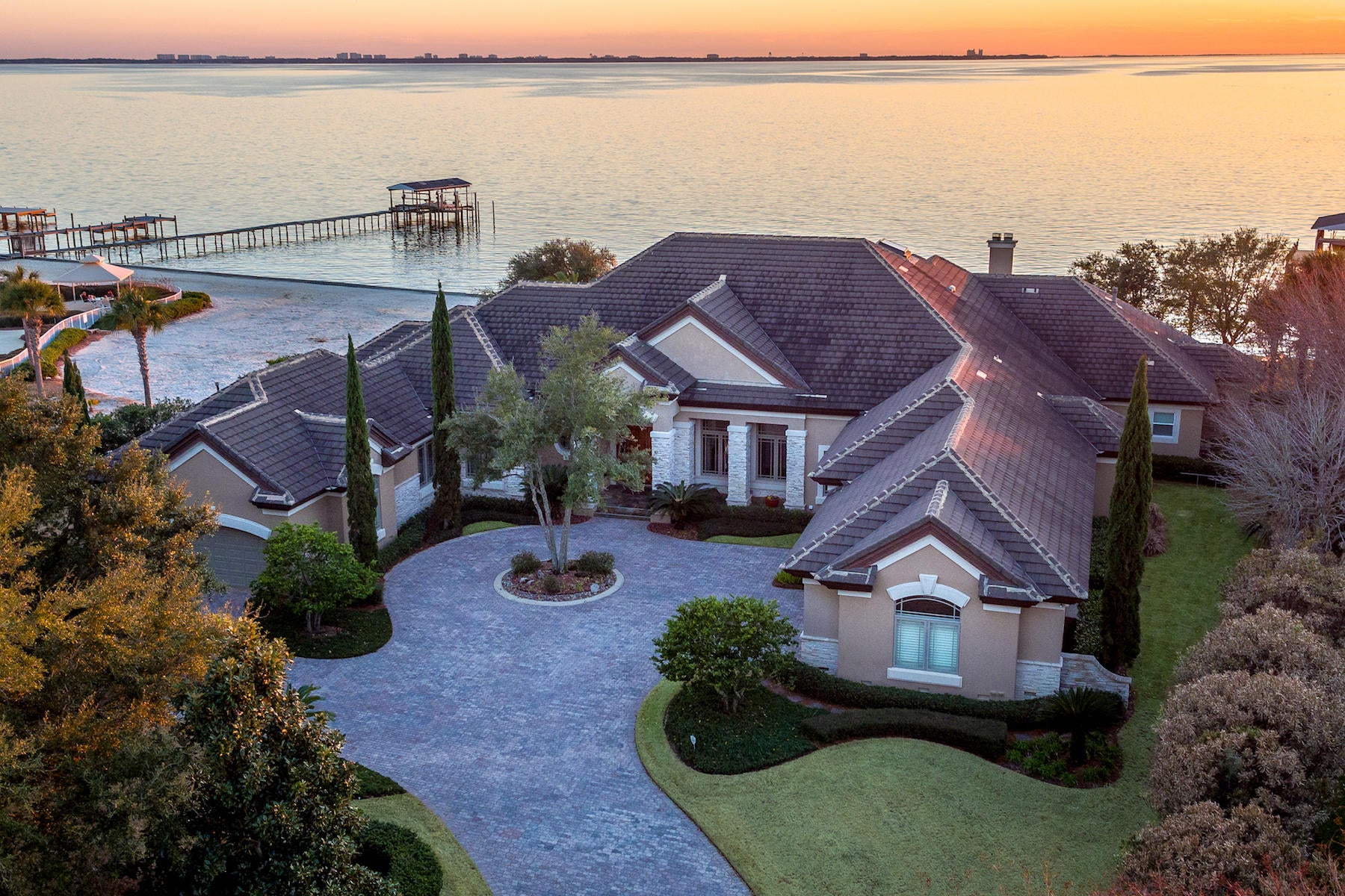 A very special home! The incredible lot is nearly 1 acre with 160 feet of waterfront on Choctawhatchee Bay. Located in Bluewater Bay's Sunset Beach community, the location provides a serene and secure backdrop for a quality lifestyle of making long-term memories!
From planning to choice of materials to careful execution, the home exhibits exceptional attention to beauty, practicality, structural integrity, and meticulous details. The incredible foyer features an exquisite groin ceiling and 5-piece Versailles pattern marble flooring imported from Spain, which continues throughout the common areas. It opens to the formal living area with its fabulous views and soaring 15' 2-step coffered ceiling, as well as to the formal dining room which showcases a stunning ribbed barrel ceiling and conditioned wine closet with 300+ bottle capacity.

The kitchen opens to the family room, both of which enjoy 15' ceilings. Other kitchen highlights include a motorized skylight with remote control/timer, custom cherry cabinetry, center island with a unique Elkay Mystic river sink, Thermidor Professional 36" gas range, KitchenAid Superba double oven, microwave, convection oven with ultima cook and warming drawer, KitchenAid 48" refrigerator, Miele dishwasher, Aquapure water filter, and much more!

The media/game room is next to the kitchen for ease of entertaining, yet concrete construction provides an excellent noise barrier. Beautiful wood beams, a wet bar, 2 mini-fridges, an icemaker, and a custom gas fireplace add to the special ambiance of this gathering place. 

The intelligent floorplan provides for maximum privacy and comfort in the various bedrooms. The master suite offers a beautiful 2-step tray ceiling, sitting area, fountain-style jetted tub, beveled glass with stunning views in the bath, and 3 walk-in closets (his, hers, linen). Two additional bedrooms, one with water view, have their own ensuite bath, while 2 bedrooms share a bath. The guest suite with separate entrance includes a living area, mini kitchen, bedroom, bath with dual sinks, and private patio.

Sure to be a favorite is the 1065 SF screened back porch. It includes a cypress ceiling, 5 ceiling fans, marble flooring, and a wood-burning fireplace, making it perfect for year-round use. The 16x32' heated, salt water pool offers an Aqualogic control system and has just been refinished and re-tiled with a brand-new pump. The raised spa heats up in as little as 15 minutes. The home's third fireplace is on the private sundeck on the roof, allowing it to be comfortable both day or evening.

The home's southwesterly orientation is perfectly situated to enjoy stunning bay and sunset views without incurring direct western sunlight. The brand-new 180' boat dock includes a lift, electrical power, and water. The residence is reached by a circular brick paver driveway which will accommodate up to 20 cars, plus there is a 3-car main garage and 1.5 car garage off the guest quarters.

Superior construction includes ICF, cement tile roof, geothermal HVAC system, impact-resistant windows, 3.5" steel columns encased in concrete, and a whole-house generator. Other conveniences abound, such a "mud" room area, 8 additional closets, 2 large floored attic storage areas, and exterior closet for storing boat toys. The exerior masonry has recently been re-stuccoed and painted.

This beautiful residence invites you to the best of bayside living!
The Buyer must verify all specifications and information.