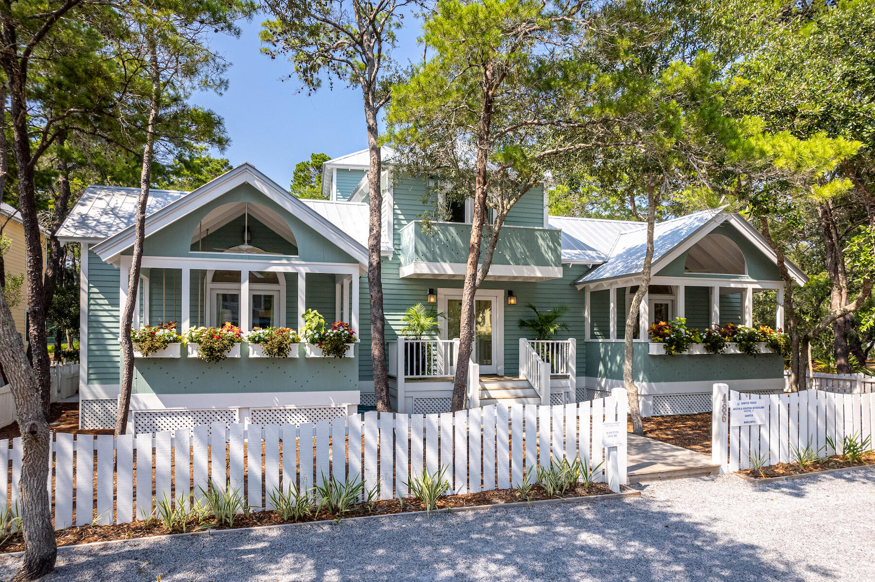 Step Back in Time to a Seaside Classic - the Sawyer House. Capturing the spirit of the carefree early Seaside days, this classic Florida cottage offers a welcoming and friendly presence as it stands comfortably nestled amid the native landscape of live oaks and sand pines. The interiors of this charming cottage with separate guest quarters were recently updated by Tracery Interiors. Located steps from the playground, tennis courts, and swimming pools and is just a short stroll to the emerald waters of the Gulf of Mexico. The large property, measuring 70 by 75 feet, offers incredible flexibility for expansion. Like many of the best early Seaside homes, the rich traditions of vernacular architecture found in historic small towns and older beach communities inspired the original design of this home. Similar to classic beach houses that have stood along Florida's shoreline for generations, this home takes advantage of shade and Gulf breezes with deep porches and breezeways to encourage camaraderie. The house is an authentic classic, a most fitting and appropriate response for 30A's unique coastal environment and relaxed lifestyle. Simple materials and carpenter details give this house its distinctive character both inside and out. Exterior cladding is cedar with extended roof overhangs and a traditional metal roof. Familiar forms translate to a pair of deep front porches crowned with pitched gabled roofs. A playful white picket fence frames the street front, while a wooden pathway leads to the entry French doors that establish an inviting first impression.  A thoughtful and efficient arrangement of interior spaces captures the best aspects of an open floor plan designed for casual beach living. The spacious living area is filled with a multitude of windows and French doors with vaulted ceilings, flooding the space with natural light. Warm pine floors and crisp white tongue and groove wood paneling instill charm and character throughout the home. The living room and master bedroom share a fireplace surrounded by marble. A custom-built curved staircase leads to a large loft providing additional sleeping space. The kitchen includes a breakfast bar that seats four comfortably along with a sitting area. A wet bar is tucked off the kitchen next to the staircase. The guest bedroom and bath are located just down the hallway. Every room of the main house opens onto a private dining courtyard. The screen porch is the perfect hideaway for a quick nap. The separate guest quarters include an efficiency kitchen with one bedroom and bath. The first level of the guest quarters houses the laundry and storage room for the main house and is easily accessible off the courtyard. If you've always wanted to own a Seaside home, this classic cottage is the perfect opportunity.