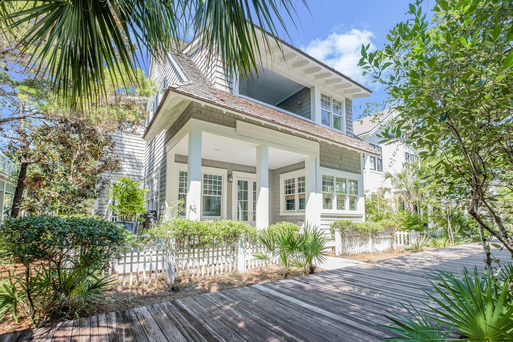 Displaying all the benefits of an extensive 2019 remodel, this luxury beach house enjoys a prime location. Backing onto a boardwalk, it's just seven homes back from the pristine sands of WaterSound Beach for morning dips and sunset strolls. Step onto the front porch where cushioned seats invite you to watch the world go by beyond the white picket fence. Inside there's a bright foyer and open great room with airy coffered ceiling. This spacious room is perfect for gatherings, vacations and celebrations. At other times, curl up on the sofa in front of the beautiful floor-to-ceiling stone fireplace with its wooden lintel and enjoy a more intimate ambiance. New bamboo flooring flows seamlessly through the formal dining area into the remodeled gourmet kitchen. Cooks have everything at their fingertips with a four-burner cooktop with griddle for creating pancake breakfasts and full-scale entertaining. There's a cozy breakfast nook that deceptively seats nine for casual dining on leather banquettes. A custom pantry hides everything neatly out of sight. Outdoors, there's a screened dining porch and wraparound open porch. Add a carriage house or private pool if you wish. Two master suites, one on each level, are beautifully proportioned with recently remodeled en suites. Rejuvenate in the steam shower or deep soaking tub after the day's activities. Guests will appreciate the media room and three more bright and spacious bedrooms. Stroll to the neighborhood pools, fitness center, puttering park and neighboring Camp Creek Lake. With coveted 30A shopping, dining and entertainment on the doorstep, it's all part of the unbeatable WaterSound lifestyle.