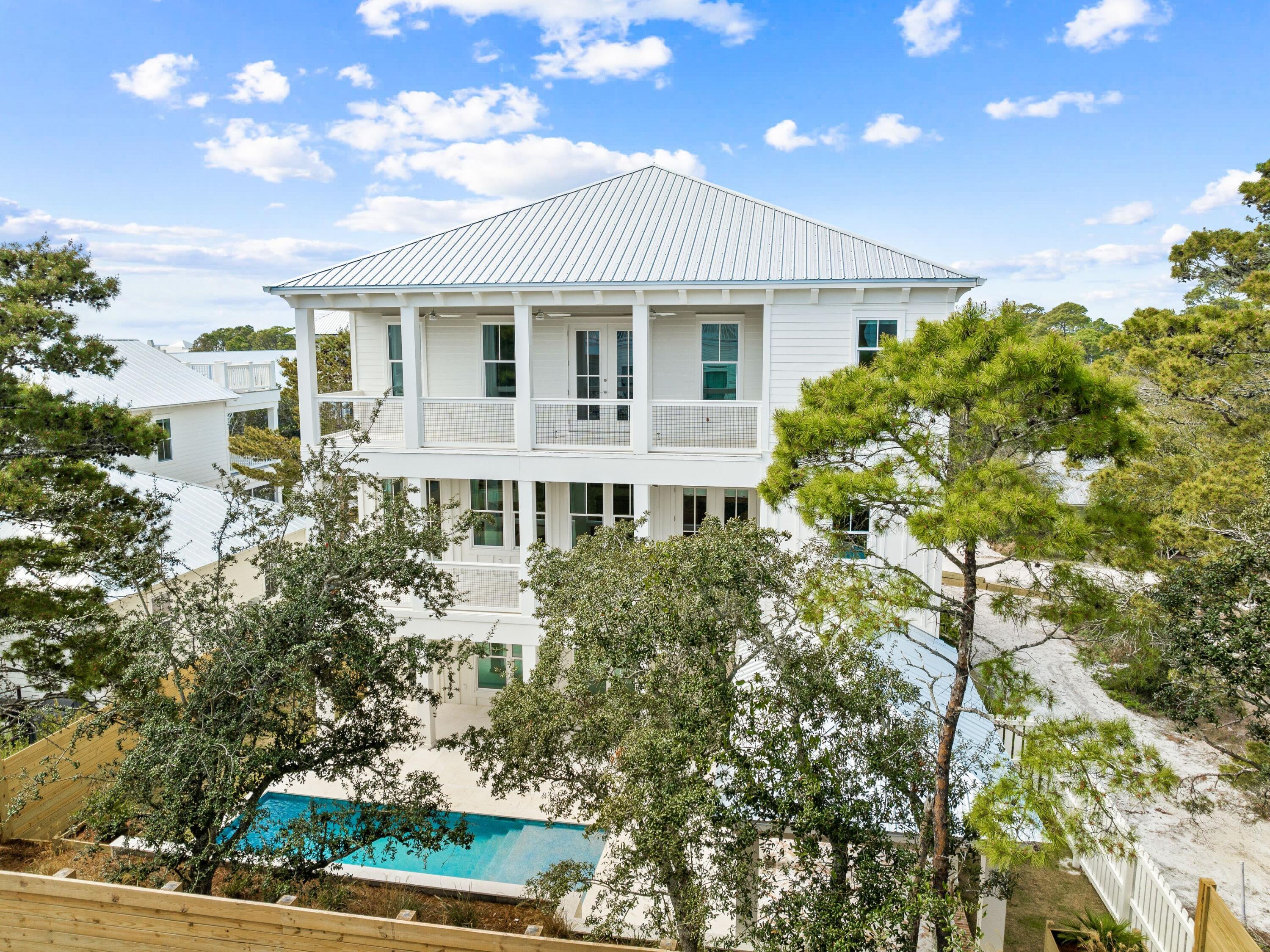 For those dreaming of a beach house beyond the ordinary, take a look at this brand-new, one-of-a-kind custom beauty.  Complete with designer wallpaper, feature lighting, handpicked artwork and high-end furnishings by local designer, Après Sun,  it's quite unlike anything else on the market. Every space has been thoughtfully honed to combine European aesthetics with practical functionality. Rising from street level, this three-story home is fronted by a wide paved driveway and lawns edged with color-filled flower beds. A two-car garage accommodates vehicles, bikes and beach toys, while a covered porch frames the grand entrance. Explore the spacious pool room with sitting area, the laundry, bunk room and the pool bathroom on this level. On the second floor, wood flooring perfectly contrasts the light stone archway, which separates the dining area and the comfortable sitting room from the chef's kitchen. Imagine entertaining and memory-making with family and friends in this attractive space. A kitchen island provides seating for snacks and everyday mealtimes. White-washed walls, stainless steel appliances and veined quartz countertops enhance every inch of this enviable chef's domain. A butler's pantry and a custom hood over the range are just some of the added delights. A half bathroom and the first of two master suites complete this level. You'll want to check out the spacious walk-in closet and the stunning master bathroom with custom tile. 

The third-floor master suite is a peaceful sanctuary of tranquility. It includes a custom walk-in closet and a master bath with accent wallpaper above the twin vanity. The covered porch is perfect for enjoying private moments of relaxation at the start and end of each day. A cozy sitting area, laundry, and three additional bedrooms complete the generous accommodations. The loft is cleverly used as an additional TV area with a beverage refrigerator and bar for guests to help themselves to an array of drinks and snacks. Bathrooms have been individually designed using stylish tile and frameless glass shower doors. 

Outdoors, the rear fenced yard is centered on a contemporary heated pool complete with a tanning shelf and visual water jets. The pool view can be enjoyed from multiple balconies and outdoor relaxation areas. A lengthy covered gazebo provides the perfect place to unwind or dine with friends. For morning walks, stroll along the nearby white sandy beach and watch diving pelicans and playful dolphins in the beautiful gulf waters. Three beach access points and a nearby golf course create a retreat that's a coastal paradise beyond compare. Hop on bicycles, and in just four minutes, you can be browsing the shops and enjoying the live entertainment and restaurants at Gulf Place. Combining exceptional design with high-end finishes and a prime location, this unique residence provides a rare opportunity to experience 30A living at its very best.