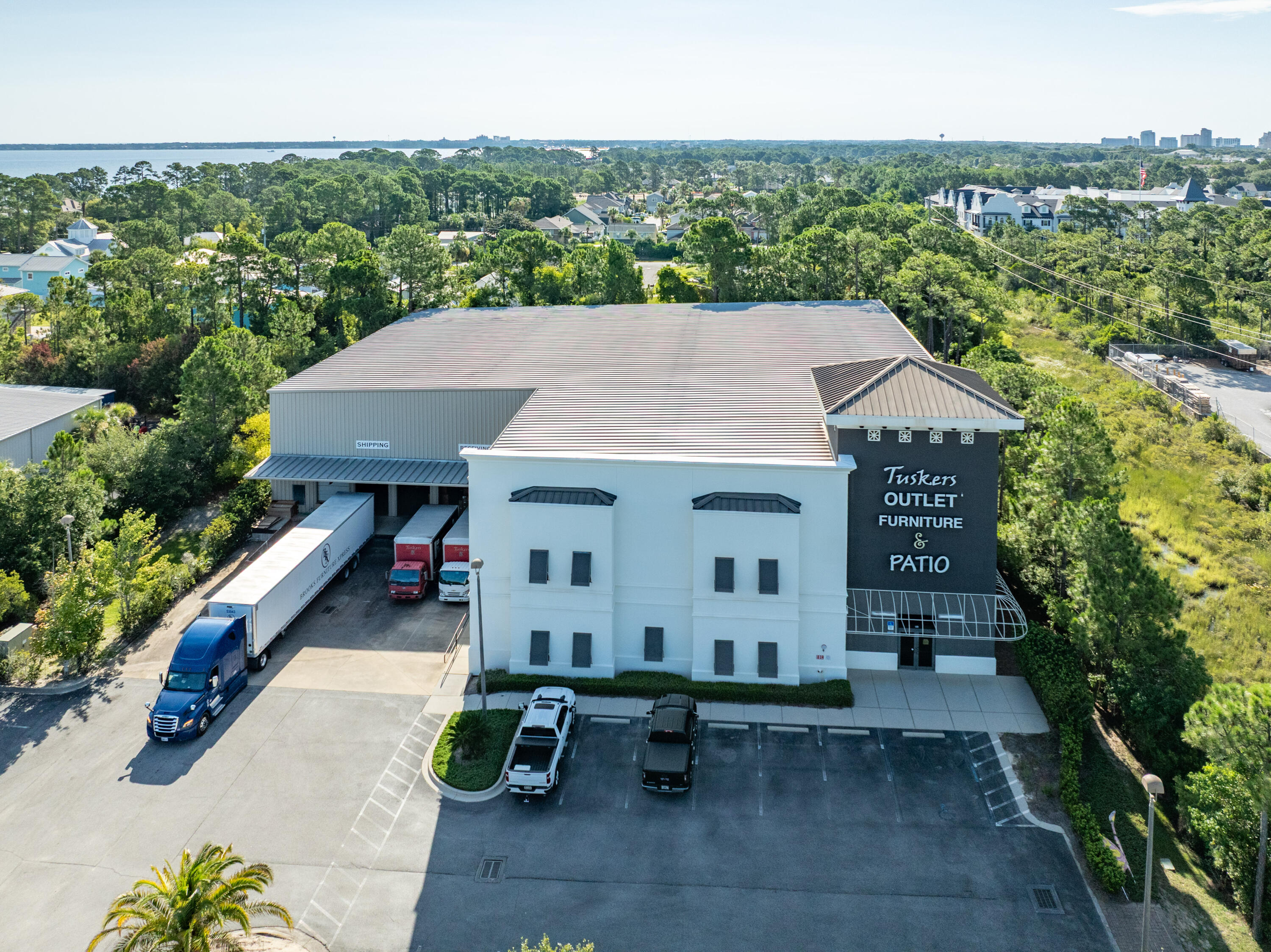 This subject listing offers the Tusker's warehouse, excluding the freestanding retail building fronting Highway 98 (freestanding retail building also available via MLS 978842). This rare assemblage of prime retail, showroom, and warehouse does not currently exist in the local market, which is adjacent to the synergistic retail nucleus of Silver Sands Premium Outlets and centralized to all the local mixed-use districts, successfully drawing population from all local peripheral sub-markets, including but not limited to Destin and Scenic 30A of Santa Rosa Beach, Florida. Fronting Highway 98 in Miramar Beach, nearly 50,000 vehicles pass by its 196 fronting feet daily, which ingress and egress lures the traffic into the retail facilities through the convenience of... the traffic light at N. Geronimo Street and Highway 98. The current owner has committed significant capital to renovate both buildings, which even includes approximately $300,000 for new escalators to service the second floor of the main showroom. Parcel 1 contains a two-story building, oriented on ±1.18 acres, hosting prime retail and showroom space, as well as private offices, collectively measuring ±26,893 conditioned square feet. There is a 3rd floor that accommodates a spectacular executive office, accessible via a private & secured "floating" staircase. The structural integrity of the building is phenomenal, and the finishes throughout are exceptional. Parcel 2 contains a warehouse, office, and showroom, situated on ±2 acres, and constructed in 2004, measuring ±11,282 SF on two floors. The warehouse contains a broad loading dock area and massive rack system with a lift and guide rails. Both buildings project an architecturally magnificent image. This opportunity is irreplaceable locally, as land development code would neither accommodate this massive yield, nor would a developer endeavor upon such a project, as the inflationary costs of this era, coupled with land costs, (even if such prime vacant land at a traffic light were available, which is non-existent), would likely much exceed $20,000,000+. The current business is operating a record-breaking levels, year over year; thus the attributable value to this extremely prime site and assemblage is likely understated. All showings are by appointment only and require a minimum of 48+ hours advanced notice. The listing broker must accompany all showings. Financial credentials are required prior to confirmation of any showings. Please do not approach any onsite staff.