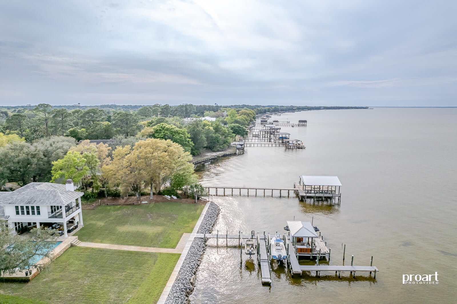 Welcome home to the highly coveted community of Estates at Indian Pointe.  This custom built one owner retreat is positioned on an expansive 1 acre lot with 115 feet of water frontage on the beautiful Choctawhatchee Bay.  This true estate begins as you enter the gated driveway that winds beneath a canopy of beautiful mature oaks and ends with panoramic views of the bay as well as some of the most spectacular sunsets found anywhere in Destin!  This 5 bedroom and 4 bath home is ready to impress as soon as you open the front door to find a beautiful open floor plan that immediately encompasses the expansive water view.  Large living room with coffered ceiling has 4 panel glass sliding doors and surrounds an impressive floor to ceiling wood burning fireplace with gas lighter. Wonderful chef's kitchen is tastefully appointed with Electrolux Icon gas cooktop as well as wall oven, convection oven/microwave and warming drawer.  Beautiful oversized island, tons of storage with 2 pantries and a convenient wet bar/coffee bar rounds out the perfect place to gather and entertain.  Large waterfront master suite on the first floor boasts his and her closets, expansive master bathroom with large shower and soaking tub, treyed 12 foot ceiling and a spectacular view every morning.  The first level also includes an office, dining room, waterfront eat-in area off kitchen, 3 additional guest rooms and 2 full baths.  Upstairs you will find an additional guest bedroom and full bath, as well as a large multipurpose room including another wet bar all overlooking the beautiful bay.  The 2nd level is perfect for giving guests their own private space that includes a large slate balcony that also overlooks the saltwater pool.  Beautiful hardwood throughout, 12 and 14 foot ceilings, impact glass, renai water heater, 3 a/c units, spray foam insulation, 3 car climate controlled garage, oversized parking area, waterfront pool and hot tub...oh and don't forget about the outdoor entertainment area with a summer kitchen, another wood burning fire place, and commercial heaters in the ceiling to extend the outdoor season.  Relax and watch the game while you sit by the pool or relax in the hot tub which is a truly perfect space for entertaining or finding your own serenity.  You may also choose to grab a drink and wander down to the dock where you will find 2 boat lifts, 2 personalwatercraft lifts, a large cabinet to store all of your fishing gear as well as a custom crafted sunken cypress bar and cabinets with a sink and another tv. Watch the sunset like no other while you wait for the dolphin to come by to feed in the early evening.  4132 Belcourt Drive is the true paradise you have been searching for offering more than just a home, but a truly wonderful lifestyle.  This all brick home with a beautiful mortar slurry wash is built to stand the test of time and allow you to focus on living your best life on the bay!