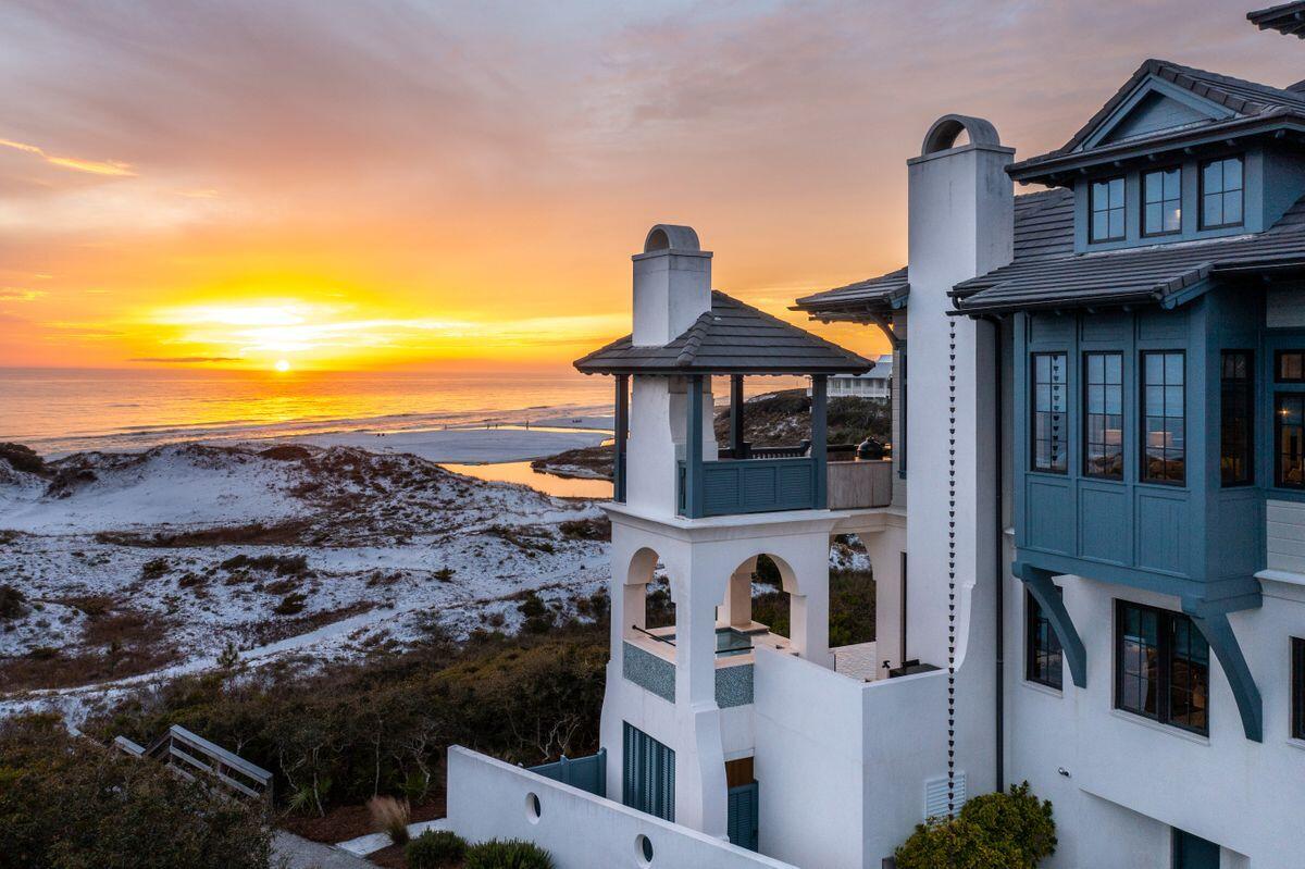 Perched atop rolling white sand dunes with limitless views of the Gulf of Mexico and Draper Lake outfall sits ''The Art of the Sea,'' a home unlike any other where design inspiration was drawn from the sea and finishes were purposefully selected to reflect a life well lived on the water. This 6,080-sq.-ft. like-new residence tucked inside the private, leafy community of The Retreat lacks for nothing with five bedrooms, a bunk room and six full and two half baths. Built in 2016, with architectural work by Archiscapes and construction by Gulfview Construction, this home is a masterclass in elegant living, from its nearly 2,000 square feet of covered porches to its one-of-a-kind infinity-edge pool and spa. The interior of the home was crafted to incorporate elements from vintage yachts such as thoughtful positioning of mahogany throughout, nautical lighting and a birdcage elevator fabricated by Saltwater Steel inspired by the vintage grand hotels in Europe. No detail has been spared including a custom mahogany, brass-inlaid staircase; four gas fireplaces with custom tile surrounds; Venetian plaster walls and ceiling finished with custom HVAC vents; and, custom millwork from E.F. San Juan. The heart of the home, the kitchen, is well-appointed with dual Bosch dishwashers, dual Sub-Zero refrigerators and freezers, a Wolf six-burner gourmet range and double oven, 100-bottle Sub-Zero wine refrigerator, and an extra-large island topped with Taj Mahal quartzite countertops. A first floor family room features a fully equipped mahogany clad bar area plus three televisions and Weathershield folding doors for a true transitional space. A spacious residential gym is currently equipped with water rower, Octane elliptical and dual Keiser spin bikes positioned among cork flooring and mirrored walls with a large fan, two televisions and open balconies. The owner's suite on the second floor features an exquisite en suite bath with heated floors, a BainUltra bubble tub and authentic porthole in the steam shower, and a jewel box sitting room to take in unmatched views of the gulf, Draper Lake and abundant wildlife. A custom library/office boasts pecky cypress accents and built-in cabinetry. A guest bedroom with porthole reading lights was designed as a custom "ship room" and a coffee bar and mini-fridge in the third-floor guest area add convenience. Other unique features of this coastal retreat include a full-light art studio with sink and TV and a kids' playroom with a jellybean nook. Notable finishes include bench crafted wood floors on the second and third levels; heated floors in the first-floor bedrooms and baths; laundry facilities on the first and second floors; Control4 lighting and sound system; Newport Brass plumbing fixtures; a Life Safety sprinkler and fire/smoke detection system; and central vacuum throughout. The exterior of the home is no less spectacular with a welcoming courtyard fountain with custom Oceanside tile, a two-car garage, Weather Shield folding doors on gulf-facing balconies, Loewen and Weather Shield windows, and air-conditioned storage area with half bath and refrigerator. Imported shell stone flows through the first floor from entry to pool. The 60-ft. infinity-edge pool and spa, designed by Cox Pools, is a one-of-a-kind offering with Penair automated controls. Commanding an unparalleled view, there is a summer kitchen complete with a Big Green Egg cooker and 42-inch DCS barbecue grill, SunBrite TV and gas fireplace all under a pavillion. The Retreat is an exclusive, gated community along Scenic Highway 30A in Blue Mountain Beach that is ensconced by native forests and 3,000 feet of private beach. Ownership in this non-rental community grants access to both Draper Lake and a gulf-front, resort-style beach club surrounded by masterfully crafted luxury residences for a coastal experience that is second to none.