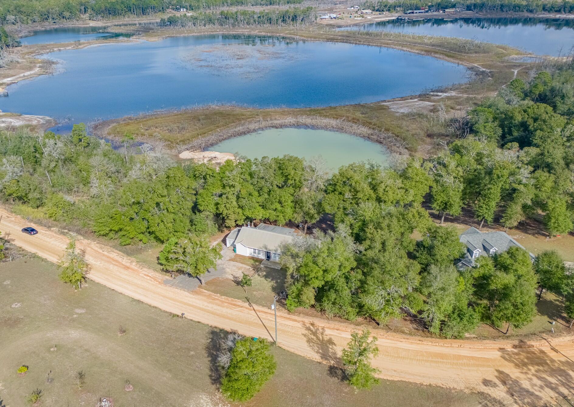 'CURRENTLY UNDER CONTRACT, SELLER WILL CONSIDER BACKUP OFFERS' Experience serene waterfront living in this beautifully appointed 3-bedroom, 2-bath residence overlooking the peaceful waters of Upper Spring Pond. Perfectly blending the charm of country living with the convenience of nearby amenities, this home offers close proximity to beaches, shopping, dining, and the airport. The inviting open-concept living area features a cozy wood-burning fireplace and expansive sliding glass doors that frame stunning lake views and fill the home with natural light. The spacious kitchen is thoughtfully designed with a picturesque window overlooking the water, creating a seamless connection between indoor comfort and the surrounding natural beauty. Generously sized bedrooms provide ample space for relaxation, while the outdoor living areas truly set this property apart. Enjoy mature oak trees, an expansive back deck, and a charming porch swing ideal for morning coffee or evening sunsets. The backyard offers endless opportunities for outdoor enjoyment, from bonfires and gatherings to swimming, kayaking, or fishing right from your own shoreline. This private waterfront retreat offers space, tranquility, and a lifestyle you'll love. Properties like this are rare schedule your private showing today and make lakefront living your reality.