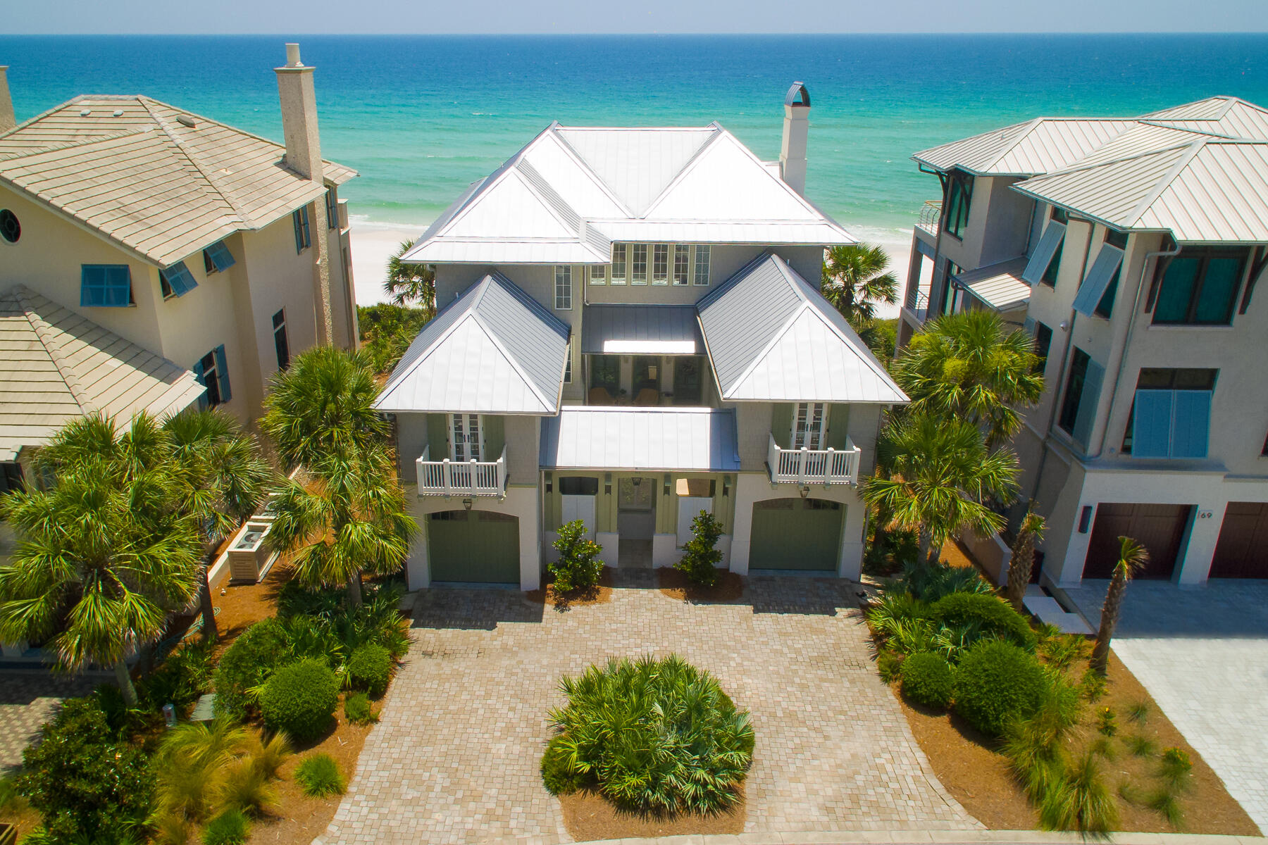 Welcome to this impeccably crafted concrete villa, where timeless elegance meets a premier beachfront location. From the moment you step through the private courtyard entrance, you'll be captivated by the exquisite finishes, thoughtful design, and striking attention to detail that define this stunning beach manor. Designed with entertaining in mind, this spacious retreat features 5 bedrooms, 5 full baths, and 2 half baths—perfect for hosting gatherings or relaxing with loved ones. Take in sweeping Gulf views from two expansive beachfront balconies, savor meals in the open-concept living and dining areas, or unwind in the generous media room complete with a full wet bar that seamlessly connects to the outdoor patio. An elevator services all levels of the home, offering both comfort and convenience throughout. Whether you're enjoying ocean breezes, toasting with friends, or creating unforgettable family memories, this luxurious villa delivers the ultimate coastal lifestyle.