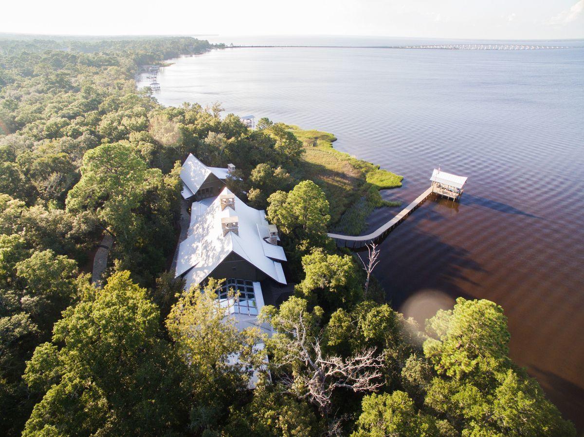 Perfectly positioned between 1,082 feet of Choctawhatchee Bay shoreline and the 15,000 acre Point Washington State Forest, is the area's premier waterfront property offering multiple recreation opportunities for a life without compromise, where grand entertaining, ultimate privacy and convenience are paramount. Strategically placed inside this gated 5-acre estate is the main house and guest house, with room for three additional home-sites to accommodate friends and family, or for investment. Designed by Matthew Savoie AIA, and built with meticulous craftsmanship by Davis Dunn Construction, this estate features grand scale, opulent finishes, restored materials and every amenity imaginable.
Seamlessly integrated into the surrounding environment and encompassing 7,995 square feet of architecturally stunning interiors by Erika Powell, both residences celebrate the art of fine living with spacious rooms revealing an artful eye for casual luxury.  Relax in the conservatory with its glass ceiling, heated floor and central fountain, and enjoy your morning coffee on the private screened back porch with expansive bay views, generous entertaining area, and stone masonry fireplace.  A six-foot-wide boardwalk with beautiful arched tree canopy leads to the boat dock that also contains a sunning and entertaining deck as well as high-speed WiFi, Sonos music, fresh water and electricity, sealed motors boat lift, fish attracting light dusk to dawn, and security monitoring.  

A small sampling of the high-end features include massive reclaimed oak beams and boards from a 100-year-old Amish dairy barn, reclaimed oak hardwood flooring, walls of wood, stone and windows offering views throughout, hurricane-rated windows & doors, whole-house dimmable LED lighting, state-of-the-art security system, 70 kW whole-home generator, and high speed fiber optic internet service. 

442 Nicole Forest from conceptual design to final execution is the pinnacle of craftsmanship, refinement and style. A magnificent achievement in an irresistible setting where richness and fulfillment in life, well-being, and meaning are all found, a place you deserve to experience.