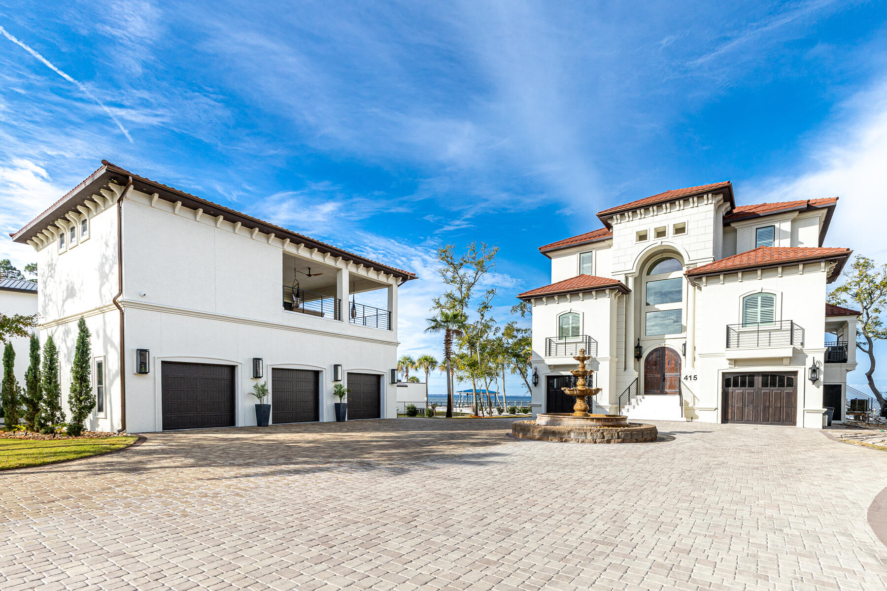 Just moments behind Sandestin Resort and Grand Boulevard's world-class entertainment, shopping, and dining, this gated, ICF built, private bayfront retreat claims 120 feet of bay frontage and year-round sunsets. From the winding paved driveway to the elegant fountain to the arched copper double doors, entering this almost 2 acre beautiful estate feels like an event. The minimalist landscaping and smart-house electronic controls ensure you can enjoy your time at home without worrying about all the fuss. The designer lighting, neutral finishes, and thoughtful furnishings, and unending views guarantee that every day is unforgettable. This luxury home is a must see for those in need of space for entertaining. An expansive stylish three-story home with an elevator and well-maintained travertine floors throughout. The main level houses a wide-open soft contemporary living room, dining room, and chef's kitchen. The kitchen is well planned to capture bay views from every corner, Viking fridge/freezer and vintage-style Viking gas range. The chef's kitchen  features custom finishes and designer details including granite counters, custom charcoal cabinets, and an upgraded appliance suite complete with two Miele dishwashers. Flanking the kitchen, a deep balcony overlooks the dramatic infinity pool with fire features, currently nearing completion. Three guest suites, 2.5 baths, and a large laundry room complete the well-planned main floor.

Your private elevator leads up to the owner's penthouse level. Leave your cares behind as you walk into the private ensuite. This expansive retreat includes a substantial seating area with private stacked-stone fireplace a coffee bar, refrigerator, and an inviting spa bathroom with tub and walk thru rainfall shower. A private balcony invites one to linger over sunrise or sunset. Just off the suite is a sunny corner executive office. 

The lower terrace level is completely self-contained with inviting guest amenities. It boasts a surround sound movie theatre with leather seating for nine. The bonus room with half bath can be a gym, den, or 5th bedroom. Full bath and washer dryer hook-ups sit right off pool deck. The covered outdoor kitchen is a BBQ artist's dream with wall of cabinets, Viking gas grill, and GE Monogram refrigerator drawers and dual drawer dishwasher. A well-maintained dock with room for four vessels and features a 2nd level viewing deck.

A newly constructed detached car lover's custom climate-controlled garage boasts room for five cars by way of two hydraulic lifts. Keep your toys pristine in your very own carwash bay. A second-level carriage house is party-central with impressive entertainment space, a wet bar, refrigeration, stylish floating shelving, a built-in dining bar, all overlooking a massive flatscreen flanked by custom speakers. Take the party outside to an expansive 1340 sqft balcony with outdoor kitchen, and gas fire table, all overlooking pristine bay waters and those unforgettable sunsets. This property is offered fully furnished.