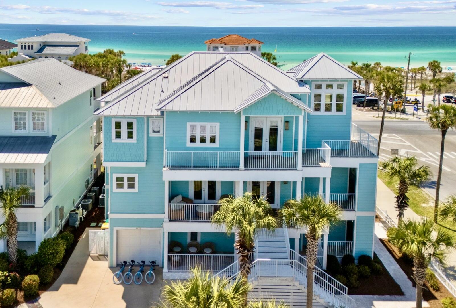 Beautifully furnished luxury home features 15-foot ceilings in third floor main living area with Gulf views! Six bedrooms and seven and a half bathrooms, this home can accommodate up to 24 guests with almost 4900 Sqft. All bedrooms located on the southside and all but one are in site of the Gulf. 
Featuring wrap-around porches, patio and decks; enjoy the breezes even on rainy days with over 3900 Sqft of covered space. Enjoy the Sun by the large private heated pool and outdoor kitchen area with 36-inch grill, fridge, sink, 80-pound ice maker and smart TV. Complete with conditioned full bathroom and changing area. Outdoor shower located right by the gate with Hot and cold water! Inside the home you'll find top of the line everything. Travertine floors throughout with Marble in the third-floor primary bathroom. Pecky Cypress accents and whimsical décor throughout. Open gourmet kitchen, living and dining room is truly the masterpiece of the Home. With 15-foot ceilings and the sparkles of the Gulf Blue waters, it is the perfect spot to eat, drink and socialize. Stainless appliances include Bertozonni 48-inch gas range, Liebherr refrigerators with dual ice makers plus undercounter 65-pound ice maker, beverage fridge and two dishwashers. Two separate laundry areas with washer/dryer. Large islands with bar seating two dining tables. Two Rinnai tankless water heaters and each floor has separate air conditioner. Elevator services all three floors and has interior and exterior stairs for convenience.  
All bedrooms have custom furnishings and décor with all having balcony and seating area. Second floor has eat-in coffee bar area with beverage fridge and sink. Built-in bunk room and billiards room on first floor each with its own full bath. Second floor has large Primary suite with custom shower and seating area. Two adjacent bedrooms that share a bath have queen and twin bed and a full. Fourth bedroom with king bed and private bathroom and dual closets. Third floor Grand primary suite has prime Gulf views with private balcony. The entire private bathroom is covered in imported Calacatta Vagli Marble with seamless glass shower and separate soaking tub. 
Corner lot with Perfect location which backs up to Scenic 98 and only steps from the Beach. Easy, walkable access to the public beach area. Quaint community has pool and lighted sidewalks for a nice stroll. Restaurant across the street is a local's favorite with live music Thursdays, Fridays and Sundays. Come check out this unique Destin Luxury home!