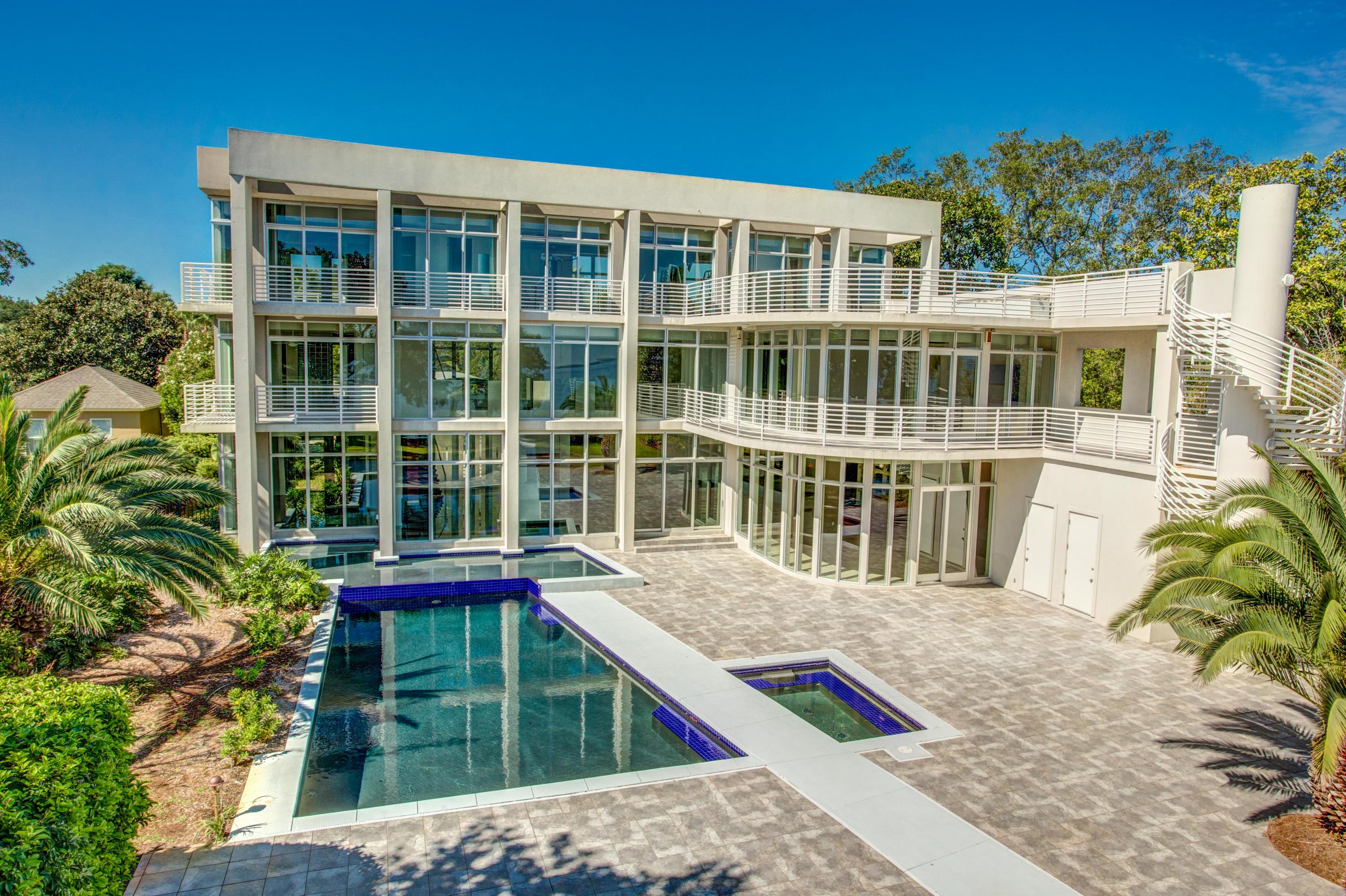 Stylishly artistic and contemporary, this light-filled residence in Destin's exclusive Cobb's Point offers a fabulous waterfront lifestyle with incredible modern conveniences. It combines many desirable elements of high end Miami-style real estate with the best of the Emerald Coast lifestyle in one special property.
The glass entrance opens into an incredible 3-story high living space with a stunning wall of windows facing Choctawhatchee Bay. The main spaces are expertly designed to flow with ease from the indoor living area with large bar, to the outdoor patio, formal dining room, fabulous gourmet kitchen, and entertainment/media room. From the floating staircase to the artistic light fixtures, gorgeous kitchen cabinetry, and mosaic tile powder room wall, each design element offer ...a uniqueness that supersedes the latest trends--thus preventing the home from dating easily--and provides an excellent backdrop to highlight your own decor and sense of style. 

In some ways this is a sun worshipper's home: it offers a gorgeous pool surrounded by a huge patio, a large top-floor open deck, balconies running the length of the home, and amazing walls of windows that flood the interior with light. Yet the ambiance is also delightful round the clockâ€”catch the sunset over the bay, enjoy your hot tub under the stars, or watch a summer storm roll in. With the security of rebar-reinforced poured concrete construction, commercial grade mostly impact-resistant windows, and a commercial grade roof, you won't have to worry about the elements.
 
The floorplan is excellent for modern lifestyles. The 4 bedroom suites are all separated and some have separate entrance options, which allows for guests, boomerang children, elderly parents (especially with the elevator), and/or a home office. The incredible master wing includes a bedroom with view, balcony, trey ceiling, and fireplace; a small room that could be a nursery or mini-office (the closet is so incredible, it's unlikely you'll need it for storage); separate water closet, jetted hot tub, large shower, separate sinks, and more. A fully equipped gym (equipment included) with stunning views is included on the third floor.

Of course, living in Destin is about enjoying the water, and the covered boat dock on Choctawhatchee Bay is a short jaunt from Crab Island, East Pass, and the Gulf of Mexico! The 1+ acre lot enjoys privacy, lush foliage front and back, and a gated entry. All with no HOA fees! If you want to enjoy both the glamour of a luxurious contemporary residence and the relaxed small-town warmth found in Destin, this beautiful property may be the right place to make your own.