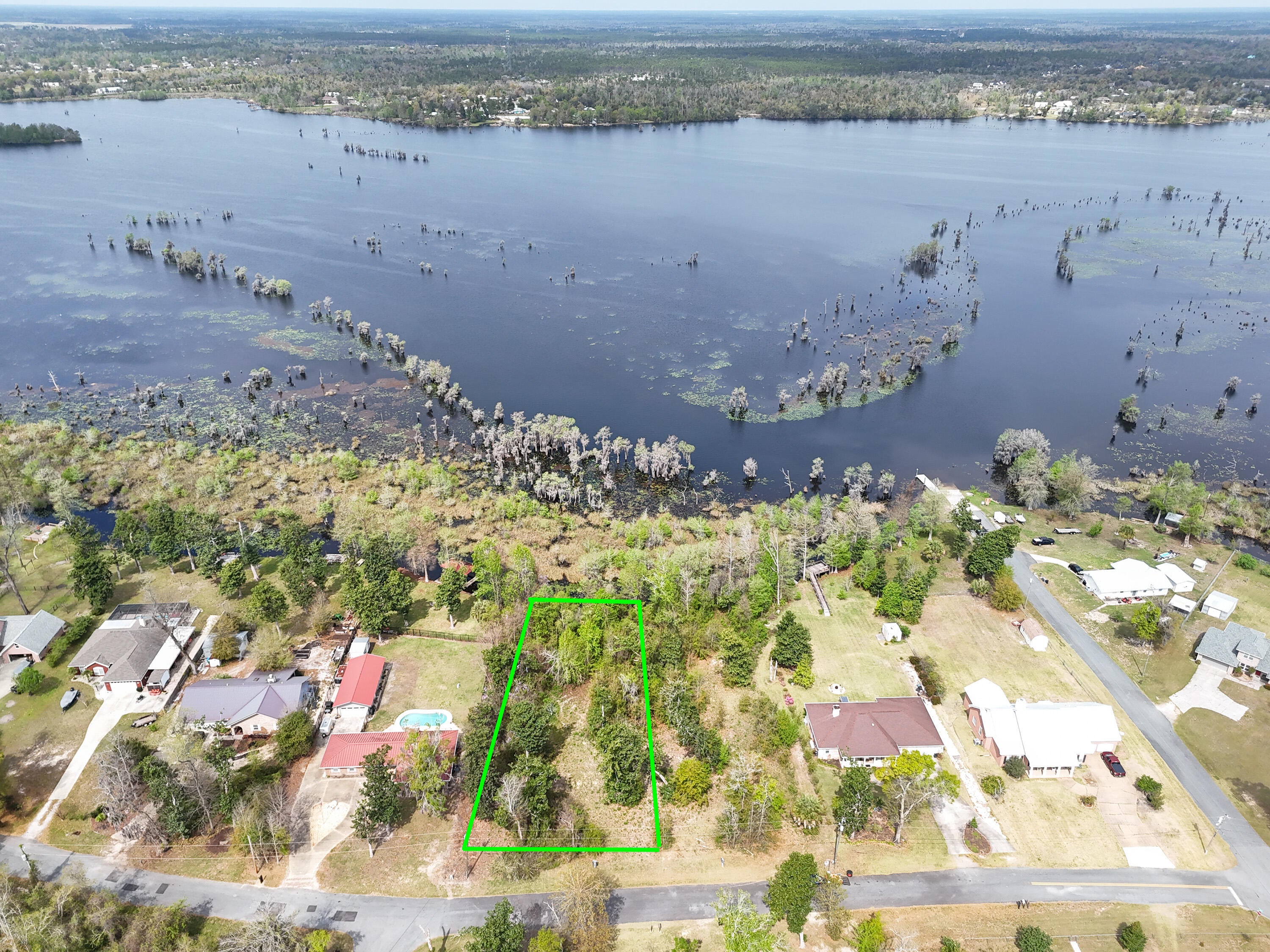 Build your dream retreat on this exceptional 0.57-acre canal-front homesite offering 100 feet of water frontage with direct access to Deer Point Lake. With serene water views & ample space to design your ideal residence, this property provides the perfect setting for a private dock, pool, workshop, or additional outdoor living features. Deer Point Lake is a 5,000-acre freshwater reservoir, formed by damming Econfina Creek, Bear Creek, and Cedar Creek, and is widely known for its outstanding fishing, boating, kayaking, and paddle boarding. Whether you envision a full-time residence or a peaceful weekend escape, this location delivers both recreation & tranquility. Conveniently situated approx 150 yards from the public boat ramp at Cedar Creek, water access is effortless. For those seeking even more space & expanded waterfront, the adjacent lot is also available, presenting a rare opportunity to own a combined 1.15 acres with 200 feet of canal frontage. This prime homesite makes an exceptional canvas for your waterfront vision with direct lake access, generous acreage, and expansion potential.