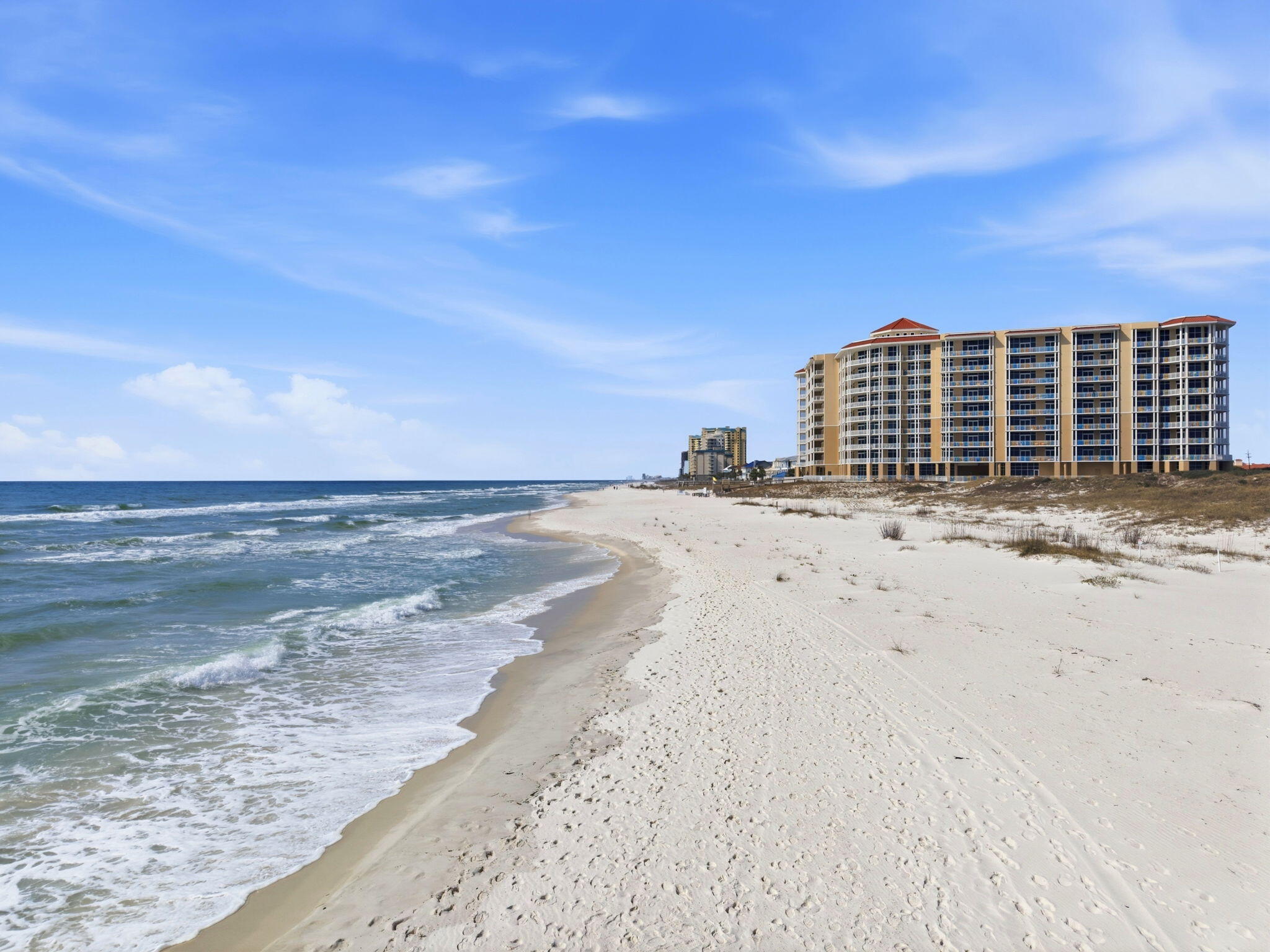 Experience unobstructed Gulf views from this exceptional 3-bedroom, 3.5-bath residence at Vista Del Mar. Positioned beside the protected shoreline of the Gulf Islands National Seashore, this 4th-floor unit offers panoramic views of miles of sugar-white sand & emerald waters. Inside, this furnished residence showcases an expansive open floor plan designed to maximize the views. Floor-to-ceiling impact-resistant glass fills the living spaces with natural light & frames the Gulf from nearly every angle. Stretching ceilings enhance the sense of volume, while elegant tile flooring runs throughout for a clean, coastal finish that is both refined & practical. The chef's kitchen is equipped with premium appliances including a Sub-Zero refrigerator & Wolf gas range, along with custom cabinetry, a generous breakfast bar, & commercial-grade stainless finishes. A wet bar with under-counter ice maker & wine chiller adds an elevated touch for effortless entertaining. The spacious living & dining areas flow to the oversized beachfront balcony, complete with a brand-new gas grill & ample space for outdoor dining & lounging. With only 64 residences, Vista Del Mar delivers a rare sense of privacy & space along one of the most desirable stretches of uncrowded beachfront on the Gulf Coast + a gated entrance, assigned covered garage parking, & private owner storage. Take advantage of unmatched amenities to elevate everyday coastal living, which includes a grand lobby featuring multiple seating areas & refined finishes, indoor heated pool, fully equipped fitness center, massage rooms that create a true wellness retreat. The owner's club room with fireplace, bar, billiards, & televisions provides additional space for gathering. Outdoors, owners enjoy an expansive beachfront deck, pool with oasis features, hot tub, & covered gathering areas. This luxury condo offers it all - a rare combination of natural preservation, architectural quality, & premier amenities! Unit is a non-rental.