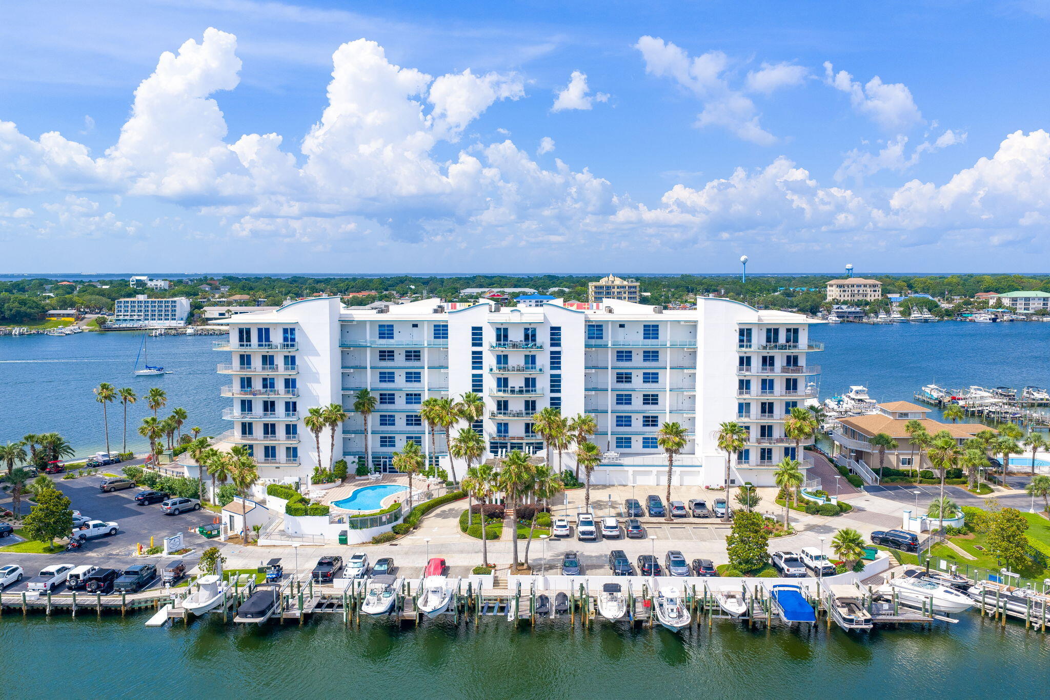 RARE 80-FT BOAT SLIP + LUXURY HARBOR C0NDO!  The largest boat slip currently available in Destin Harbor conveys with this exceptional property -- accommodating an ultra-large yacht or both an offshore and inshore vessel. Enjoy breathtaking East Pass, Harbor, and Gulf views from over 600 sq ft of wrap-around balcony, the perfect backdrop for morning coffee or sunset entertaining. The open-concept interior features a gourmet kitchen with granite countertops, custom cabinetry, and a walk-in pantry. Dining space for 8, a luxurious primary suite with ensuite bath, plus 2 additional bedrooms and 2 baths for family and guests. Includes a deeded garage and private storage locker. A rare, complete waterfront lifestyle package.