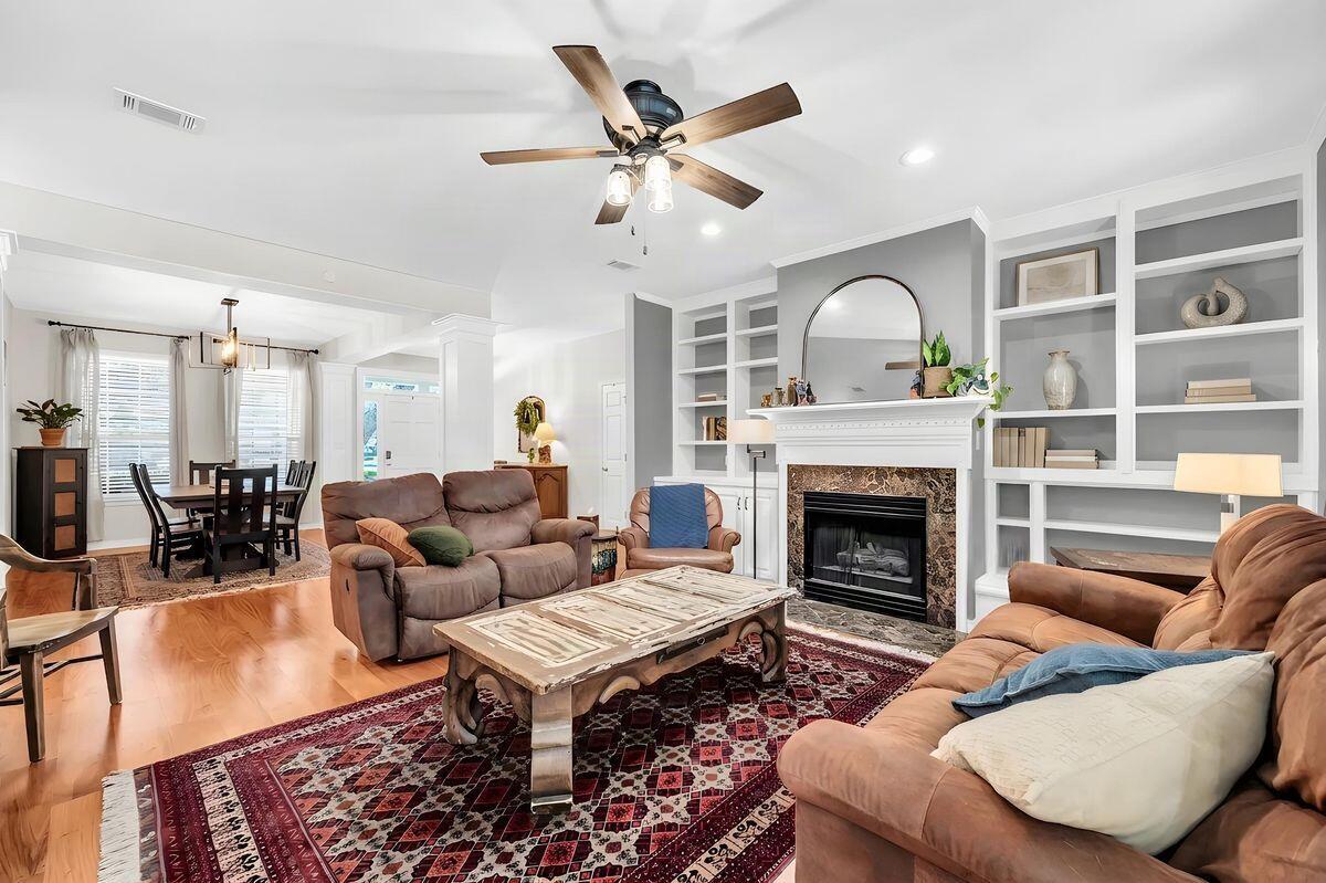 This updated five-bedroom Craftsman home in gated Southwind of Bluewater Bay is a rare find, especially considering the outdoor space. While most golf course properties sacrifice yard size for the view, this home features an unusually large landscaped and fenced backyard. It showcases a crystal clear saltwater pool while still leaving plenty of green space for everyday use. Enjoy freshly picked fruit from your own peach, fig, orange, lemon, and lime trees all while overlooking the third hole of the Marsh Course. This beautiful yard offers the perfect balance of privacy and expansive views.  The interior is just as functional, featuring a flexible two-level layout, three indoor living areas, a renovated kitchen with KitchenAid appliances and fully updated bathrooms. The home has been meticulously maintained with recent high-value upgrades including the electrical panel, a new roof, a new Trane AC unit, and reconfigured rear and front yards. Between the private pool, the oversized screened porch, and the proximity to the marina and tennis center, it's a great setup for enjoying a vacation lifestyle every day. Don't miss this opportunity