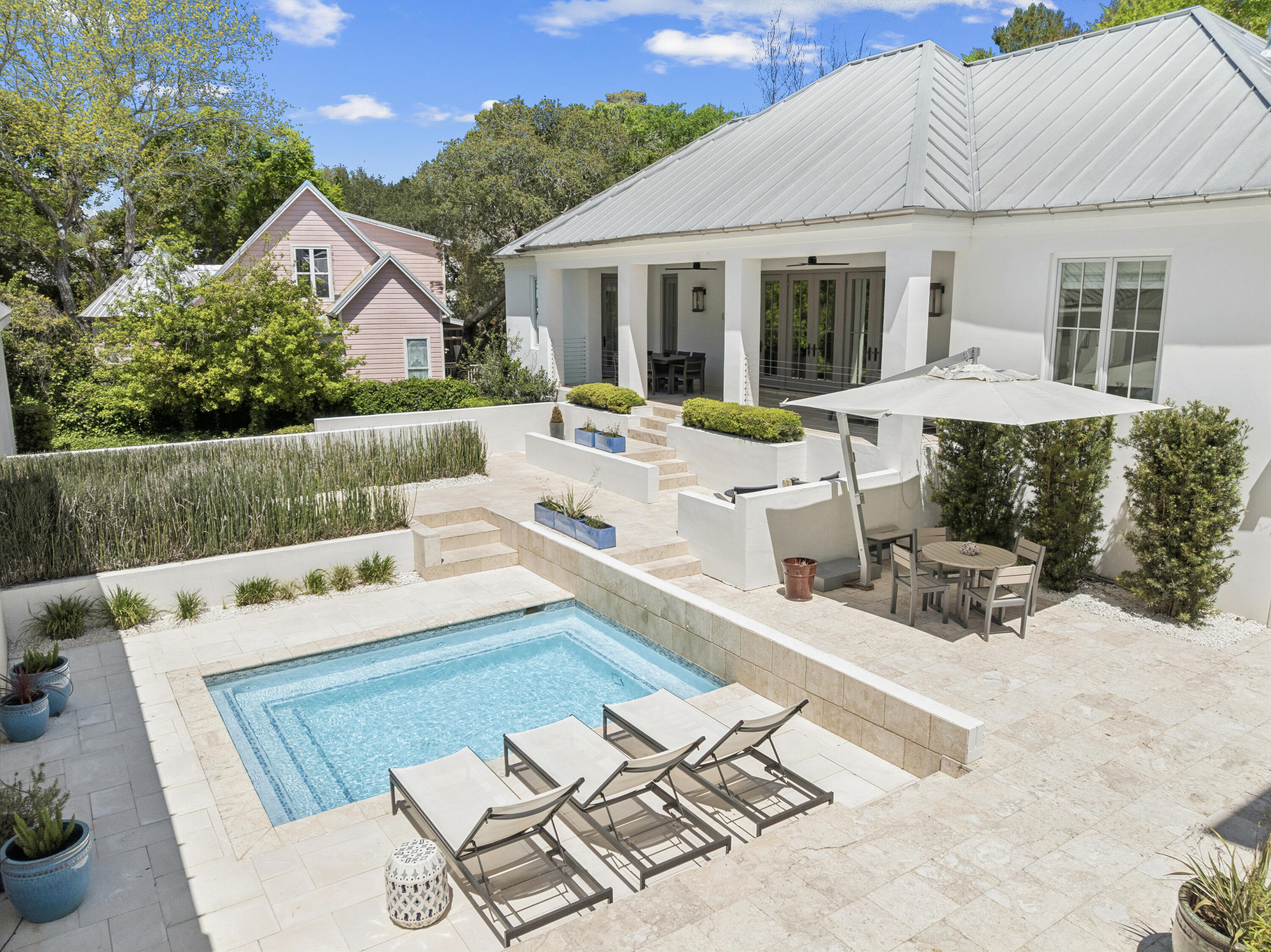 Located in the heart of Old Seagrove, this private beachside compound offers upscale coastal living just steps from the sand and from Seaside and Watercolor. This thoughtfully designed and gated property features a main residence, carriage house, and a beautiful courtyard with a resort-style pool. The interior living space is anchored by a finely appointed chef's kitchen complete with custom cabinetry, waterfall countertop, and stainless steel Thermador appliances, including a 48-inch gas range. Wide-plank oak wood flooring, custom millwork, and designer lighting extend throughout the home, while the open living area centers on a gas fireplace and is filled with natural light, creating a warm and inviting atmosphere. The main level includes three spacious king suites, each with a spa- -inspired bathroom featuring marble flooring and a glass walk-in shower. The lower level offers a second living and game area, a bunk room with queen-over-queen beds, and two additional bedrooms for added flexibility. Overlooking the pool, the ground level carriage house includes a rare full kitchen, bright living space, dining area, and king suite, ideal for guests seeking a more secluded retreat. With six bedrooms, six bathrooms, no HOA, and an unbeatable private location near dining, shopping, and beach access, this property is an exceptional opportunity to own a luxury home along 30A.
