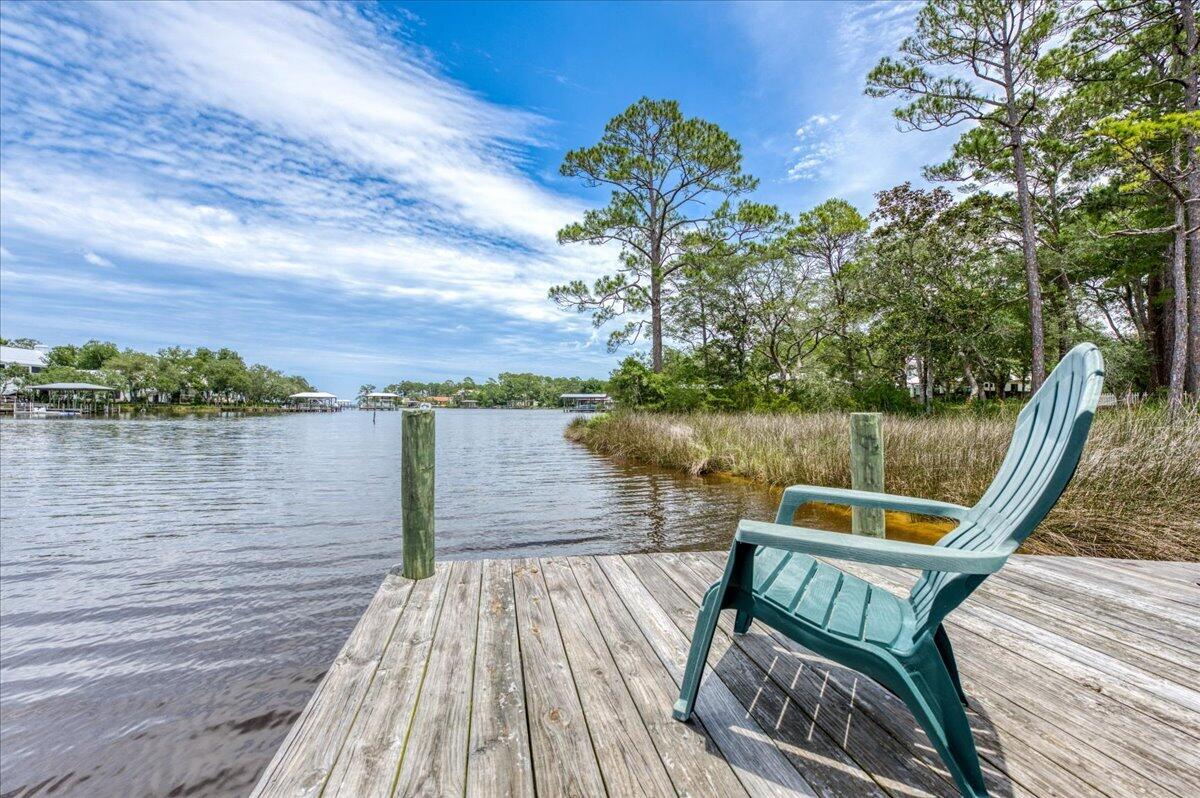 Waterfront 3BR/2BA cottage with stunning bayou views from almost every room. Screened-porch swing overlooks mature oaks and water. Primary suite features bay views, private sundeck, two walk-in closets, and separate vanity. Large kitchen w/ island opens to family room. Two screened porches, charming window seat in guest bedroom, and Mexican tile and carpet throughout. Includes boat dock & boathouse w/ lift. New roof 6/2025. New Carpet 5/26.Survey available. Unique Florida cottage you won't want to leave!