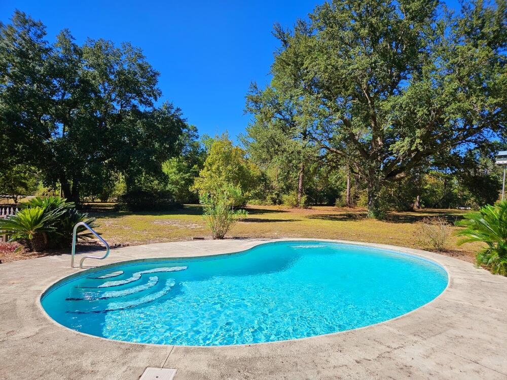 A True Diamond in the Rough! The perfect blend of space, privacy, and potential with this all-brick 4-bedroom, 1.5-bath home, nestled on 6 fully fenced, level acres. The interior has been partially updated, offering a great head start for your finishing touches. The converted garage adds versatility with a 4th bedroom, laundry area, and additional living space. Ideal for guests, a home office, or recreation.
Enjoy warm days by the saltwater pool and plenty of room to roam, garden, or simply relax in your own private retreat. A spacious barn/shop with its own power pole provides endless possibilities for hobbies, storage, or small livestock. HVAC and Metal Roof-2020