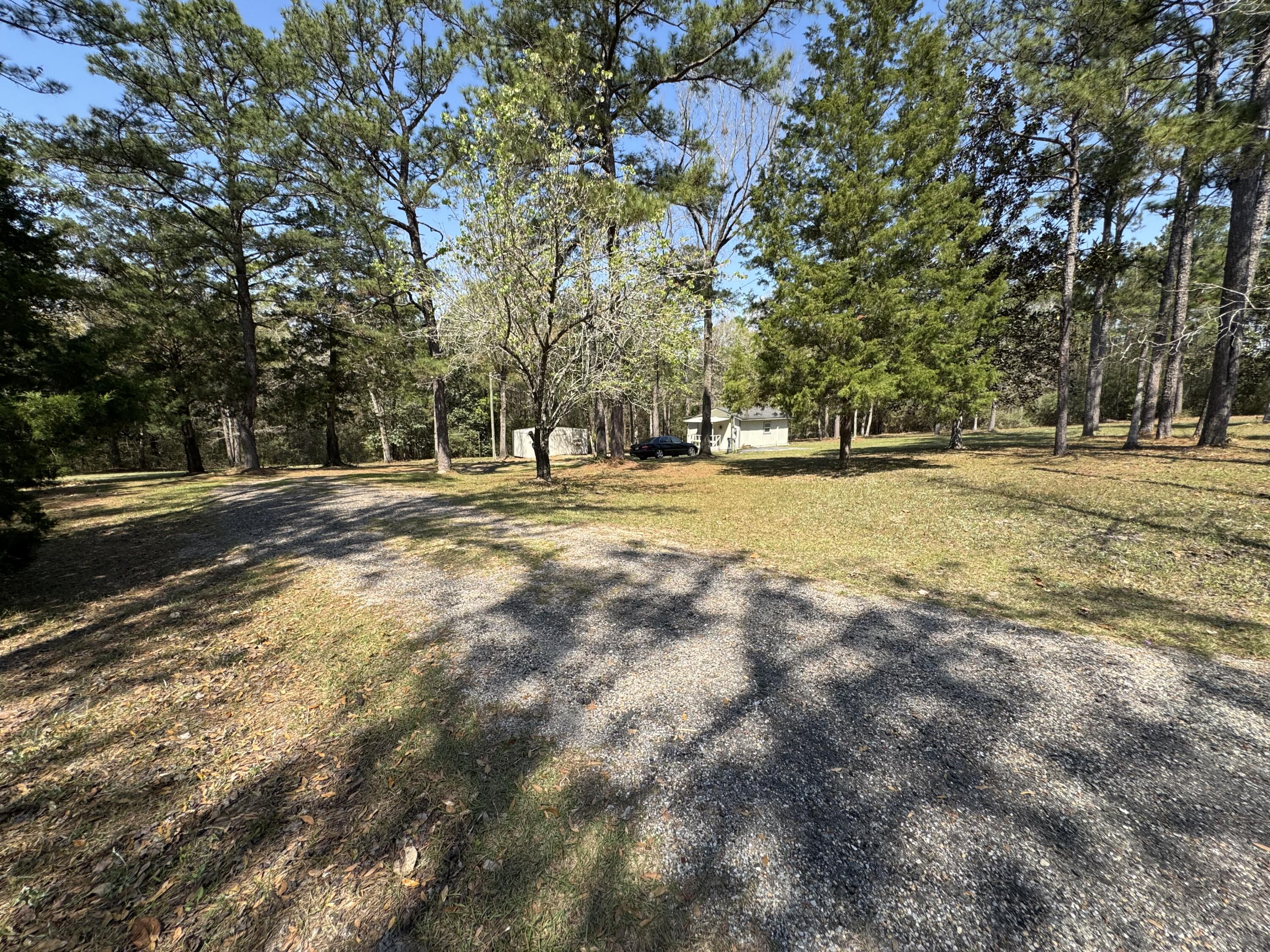 Back on Market, No fault of seller or property. Nestled on a private and beautifully wooded 1.6-acre homesite, this unique 
property offers the perfect blend of peaceful country living, modern upgrades, and future expansion potential. Surrounded by mature trees that have been professionally thinned and trimmed, the lot provides privacy while still offering ample space to build a primary residence, guest home, or additional structures. This is a charming, small home. 
The interior showcases a warm and inviting aesthetic, all remodeled recently creating a cozy yet refined living space. Many recent upgrades include new high efficiency hvac split system, new hot water heater  A complete list of recent major upgrades are provided in the attached documents. Outdoor features further enhance the property's versatility, including a dedicated RV/camper parking space with water hookup and 50-amp power, making it ideal for guests or additional living flexibility.
The property also includes a functional 12x20 storage shed and a private well house, both recently improved.

Bonus: The sale includes 2 refrigerators, microwave,  flat screen tv,  and washer/dryer, and yard tools making this a turnkey opportunity for a primary residence, weekend getaway, or investment property.
This is a rare opportunity to own a private acreage property with modern upgrades, RV accommodations, and room to expand--all in a serene, natural setting.
