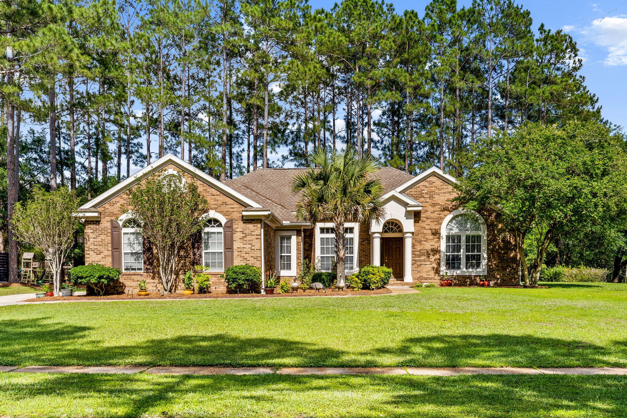 Welcome home to this cozy four-bedroom, two bath home in Windswept Estates, home to Windswept Dunes Golf Course and just a 30-minute drive to the beautiful beaches of 30a, Panama City Beach and Destin. This spacious home features an open and split bedroom floor plan, laundry room with washer/dryer, gas fireplace and a two-car, side entry garage. The screened in back patio area overlooks the serene and wooded backyard that extends with views of a pond and the golf course. The living area has tile while the bedrooms have beautiful hardwood floors. No Carpet! The primary suite offers a recessed ceiling and spacious walk-in closet while the primary bath offers a large tub, walk-in shower and a double vanity. Some additional features of this home include a new HVAC (2025), gas water heater, irrigation system (new pump), an open deck area for grilling and entertainment and a beautiful paver driveway. This all brick, low maintenance home is situated on a large lot and conveniently located in the front of the neighborhood with the amenities area close by with pickleball, tennis courts, basketball court, playground, large pool, barbecue picnic area and more. Call today to schedule a showing. Buyer to verify all information deemed important.