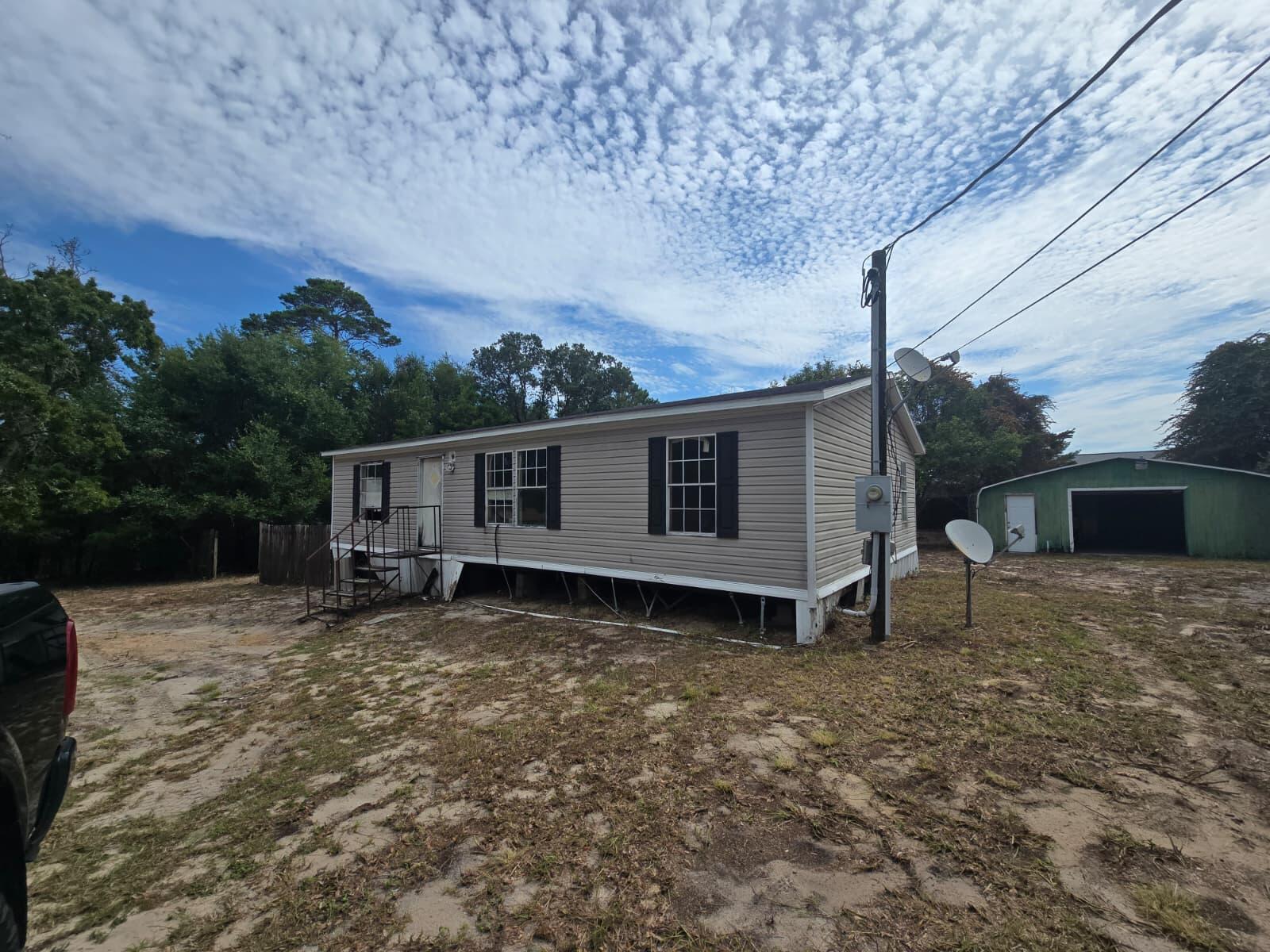 Sold AS IS with Celebration  1992 Model Double wide Mobile Home; 3 bedroom, 2 Bath with 1080 SF that needs repair and 1 Car Detached Garage. 1/2 Acres (0.496). Cash Only Sale. Flood Zone X. No Utilities turned on; South Santa Rosa Sewer, Midway Water.