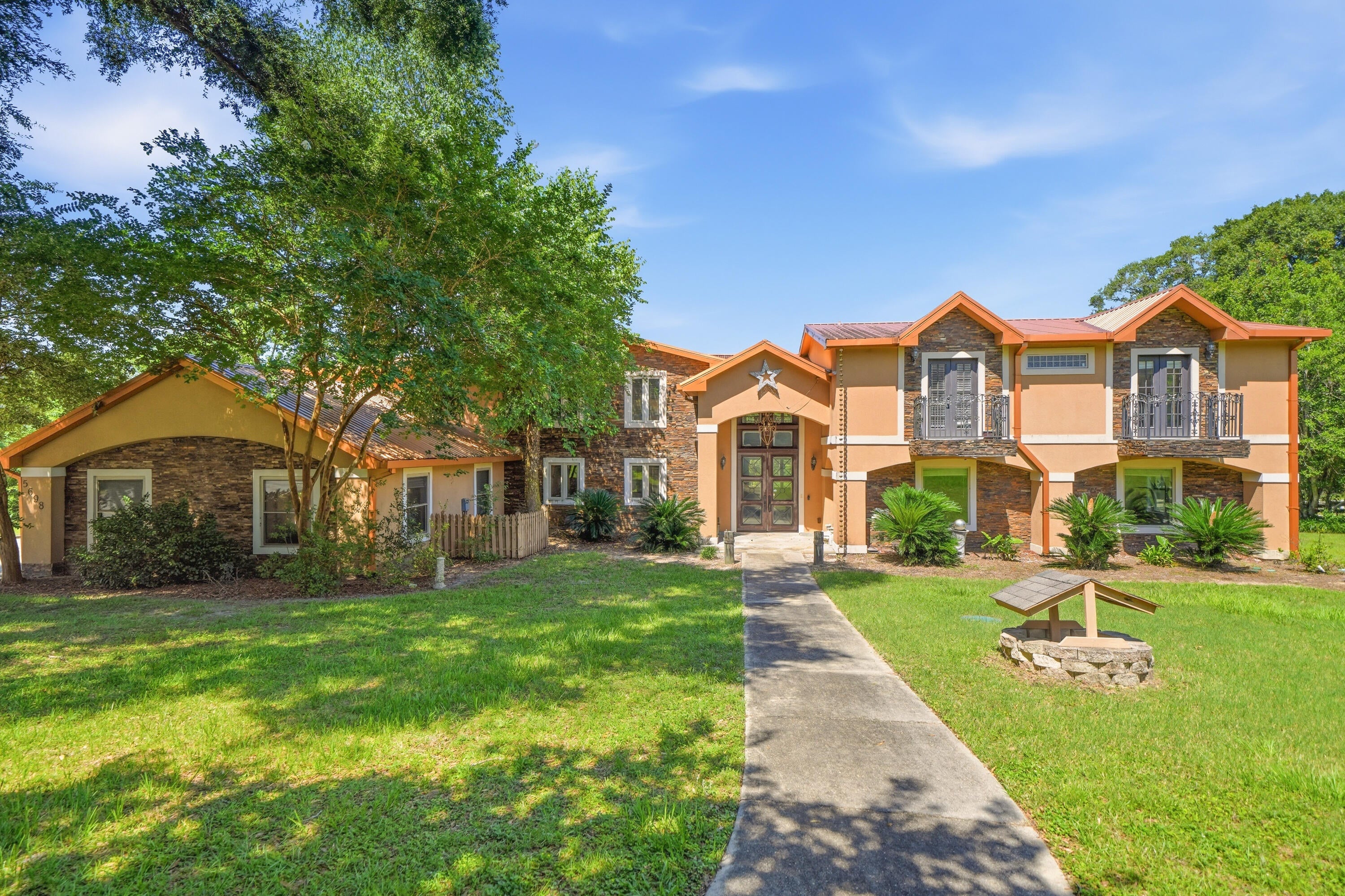 Welcome to 5698 Old Bethel Road--a one-of-a-kind lakefront estate offering space, privacy, and incredible potential just minutes from the heart of Crestview. Custom-built on approximately 1.66 acres, this expansive home has great bones and is ready for its next owner to bring a fresh vision to life.

Solid wood entry doors open to a striking marble and red onyx foyer, where a sweeping staircase and oversized windows frame views of the pool and lake. The spacious great room features wood flooring and a custom wet bar with cabinetry, refrigerator, and ice maker--creating an ideal setting for entertaining. A large fitness room with a full bathroom and walk-in shower adds even more flexibility to the floor plan.

At the heart of the home, the generously sized kitchen offers abundant counter space, a substantial breakfast bar, under-cabinet lighting, and an impressive stainless steel appliance package, including a commercial-style six-burner gas range with griddle, double ovens, an additional electric oven, and microwave. The kitchen opens to a large dining area with sliding glass doors leading to the pool, hot tub, and peaceful lake views.

The main-level primary suite overlooks the lake and opens to a private balcony with its own fireplace--perfect for enjoying cool evenings by the water. The spacious primary bathroom includes a multi-head walk-in shower with built-in seating, a clawfoot tub, and an enormous walk-in closet.

Upstairs, you'll find another large living area with tongue-and-groove ceilings, two en suite bedrooms with access to a balcony, a media room, and two additional oversized rooms offering the flexibility to serve as bedrooms, offices, hobby rooms, or guest spaces.

Outdoor living spans the rear of the home, with an expansive covered porch and balcony overlooking the in-ground pool, hot tub, and lake. Garage space is equally impressive, with a heated and cooled four-car garage plus an additional two-car garage at the rear of the property.

With its substantial footprint, lakefront setting, flexible living spaces, and unmistakable character, this estate presents a rare opportunity to restore, personalize, and create something truly special.

With an acceptable full-price offer, the seller is willing to replace the pool liner and both existing, operational HVAC systems, subject to mutually agreed-upon terms. Bring your vision and discover everything this distinctive property could become.