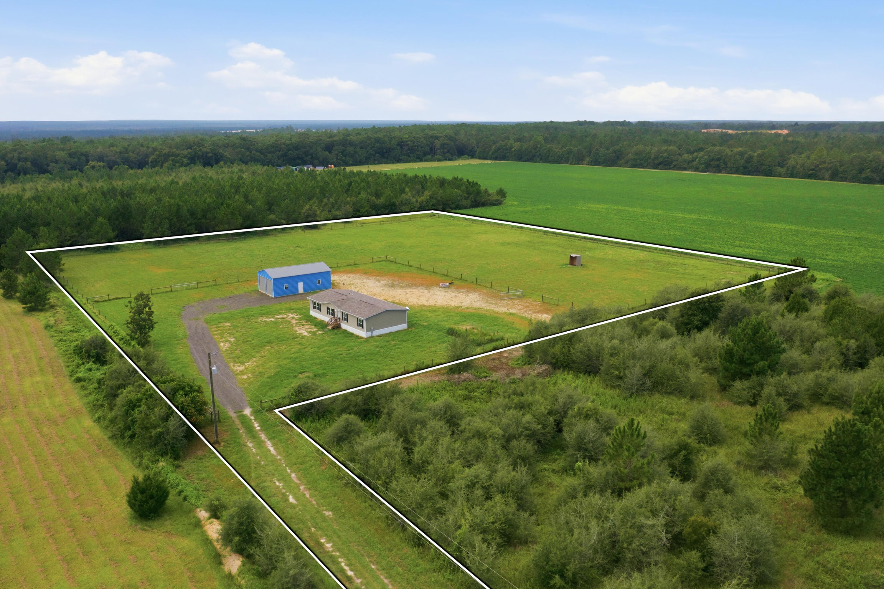 Built in 2024 and situated on 6.1 fully fenced acres, this 3-bedroom, 2-bath manufactured home offers the perfect combination of privacy, space, and convenience. Located at the end of a short road in Holt, the property feels wonderfully secluded while still being within easy reach of area amenities. The open concept home features 1,560 sqft  of comfortable living space, with gutters and a fire pit already in place. The real standout is the impressive 940 sq. ft. detached oversized two-car garage/workshop, constructed on a concrete slab with 16-ft ceilings, insulation, metal construction, and two 10-ft garage doors. There's plenty of room for vehicles, a boat, recreational toys, equipment, or workshop space. With over six acres to enjoy and the entire property fenced, this is a great opportunity for anyone looking for room to spread out, exceptional garage space, and a peaceful setting without being too far from everything. Master Bedroom Tv & Mount will stay as well as refrigerator & security system.