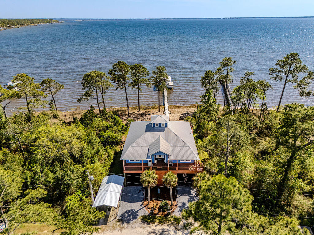 CUSTOM BAYFRONT HOME | PRIVATE DOCK | EXPANSIVE DECKS | BEAUTIFUL VIEWS | NO HOA

A rare find along the Choctawhatchee Bay. This exceptional custom waterfront home defines coastal living. The home is thoughtfully designed, and offers 3 bedrooms, 2 baths, and approximately 2,120 square feet of elevated living space, complemented by private guest quarters below.

Set on 58 pilings and .40 acres, the property delivers a true waterfront lifestyle with a private dock, covered boathouse, and a boardwalk extending directly to the open bay.

Inside, the home is both warm and welcoming--featuring soaring vaulted tongue-and-groove ceilings, rich wood finishes, and expansive walls of glass that frame panoramic water views. The open-concept layout is anchored by a beautifully appointed gourmet kitchen with granite countertops, a generous center island, bar seating, and stainless steel appliances--designed for effortless entertaining and everyday luxury.

Outdoor living is equally impressive. Expansive front and rear decks span the full length of the home, creating multiple spaces to dine, relax, and take in breathtaking sunsets and coastal breezes.

Additional highlights include well-appointed guest quarters on the lower level and dual 200-amp electrical services (400 amps total), offering enhanced capacity and convenience.

Come live the Bay life.  What an opportunity to own a private bayfront home where craftsmanship, comfort, and water views come together in a truly gorgeous setting