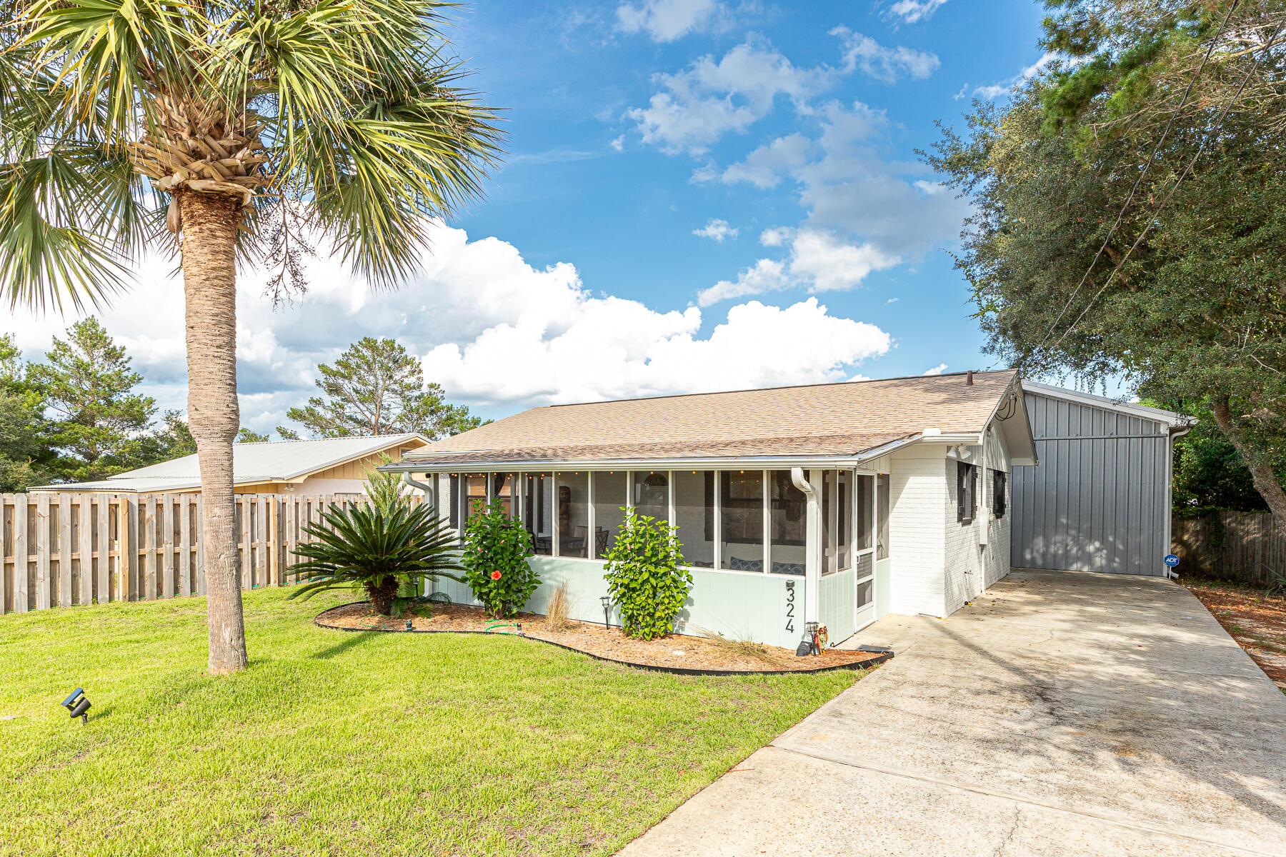 This charming property has character that is above and beyond.   Owners have thought of every detail.  The outdoor living space boasts a very large deck with an outside bar with BBQ grill, and a fire pit with lovely outdoor patio furniture all around.   Some privacy fencing. Access to both structures to the deck & grill area.. Two bedroom, one bath in main house, 3rd bedroom and bath in the detached garage building.   Garage has lots of space for a large vehicle, plus lots of storage and cabinets, etc.   Lots of opportunity to use or finish this space in other ways.   Improvements as follows: new paint inside and out, new fencing, irrigation, landscaping, plumbing, screens on porch. 2 outdoor showers.  Only 2 blocks to the beach with multiple access points.
